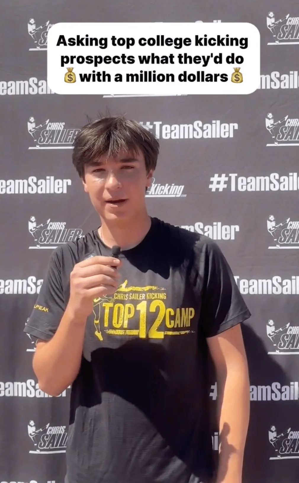 Athlete in a Chris Sailer Kicking TOP 12 Camp shirt speaking on the mic in front of a Team Sailer backdrop