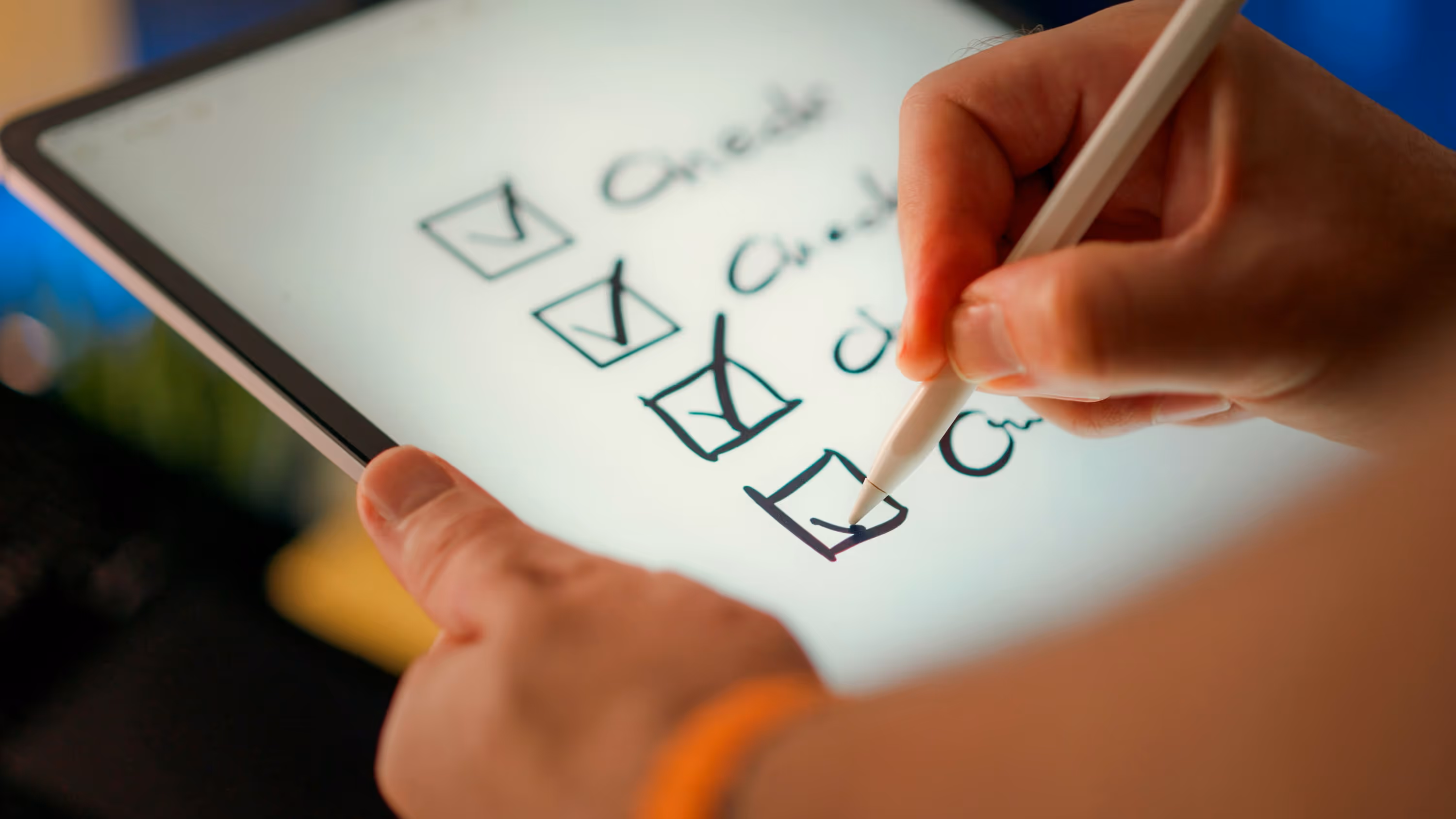 A hand uses a stylus to check off boxes on a tablet checklist
