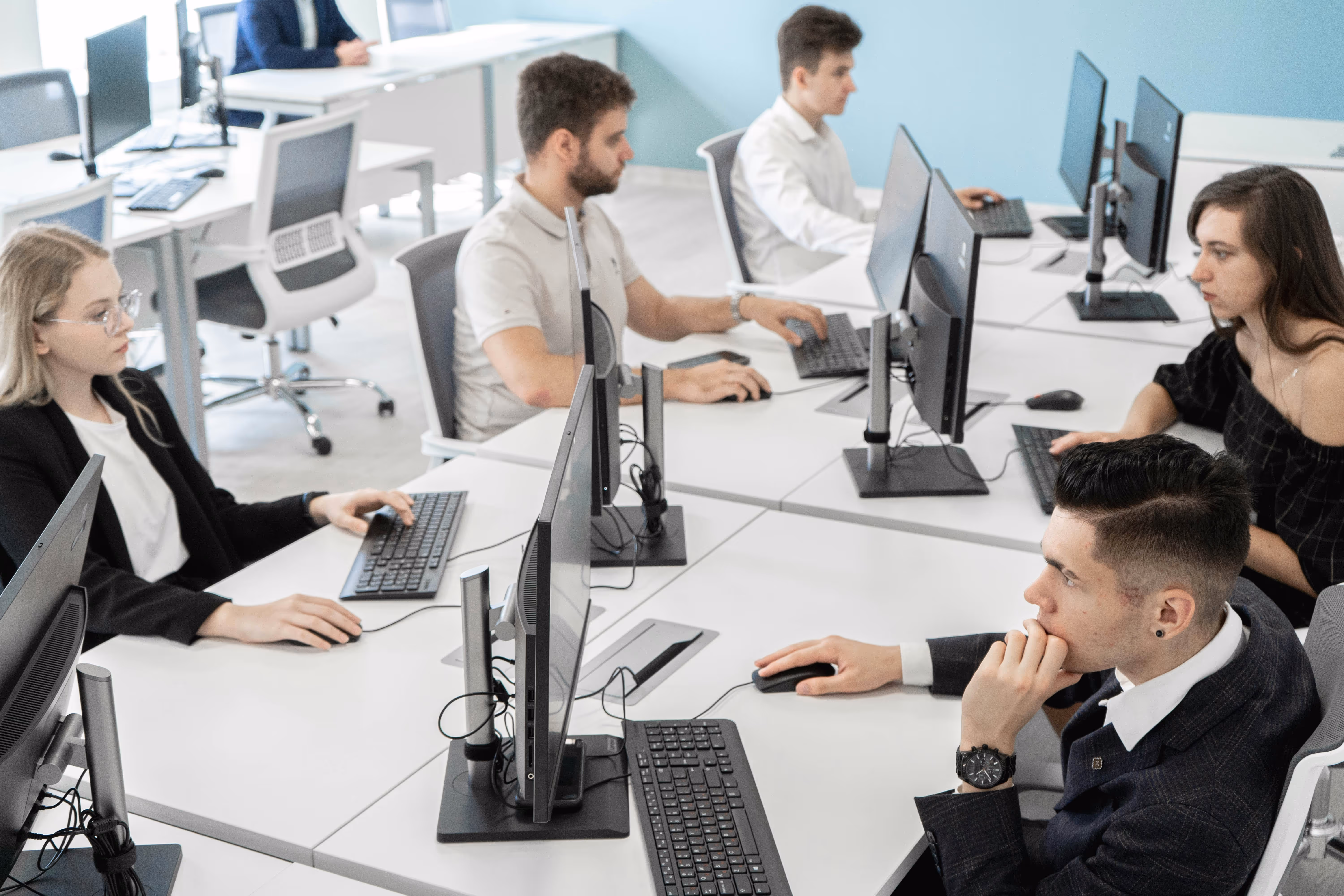 Coworkers at desktop computers working together in a bright modern open-plan office