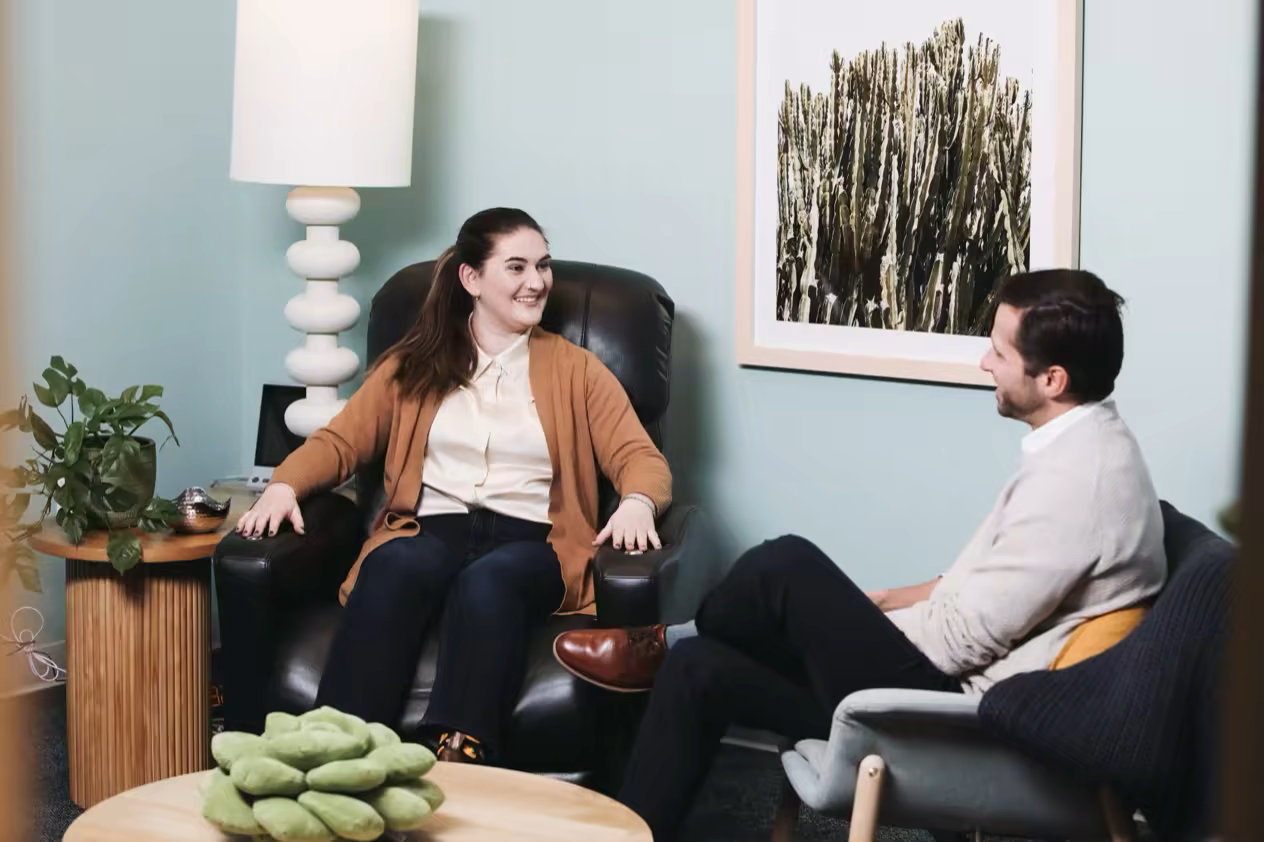 Patient and provider discussing options in a teal treatment room