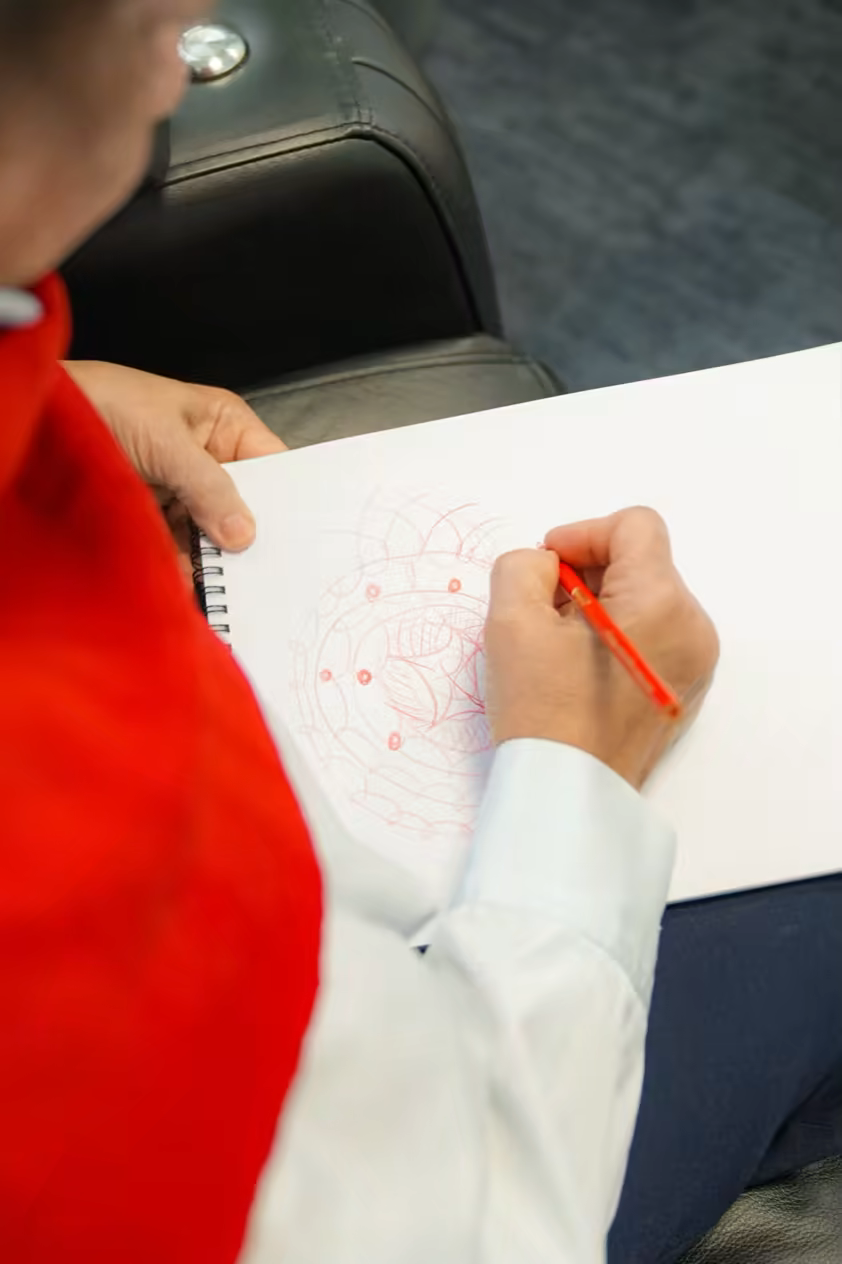 Patient drawing a mandala in a sketchbook during a ketamine session