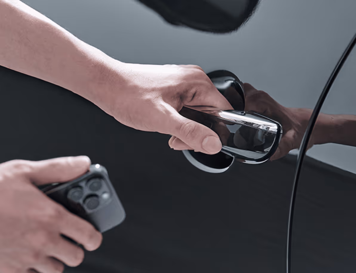 The driver is seen holding a smartphone close to the vehicle door.