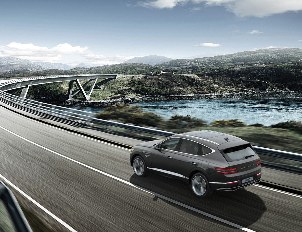 Storr Green GV80 driving fast on the highway while maintaining a safe distance from the vehicle in front.