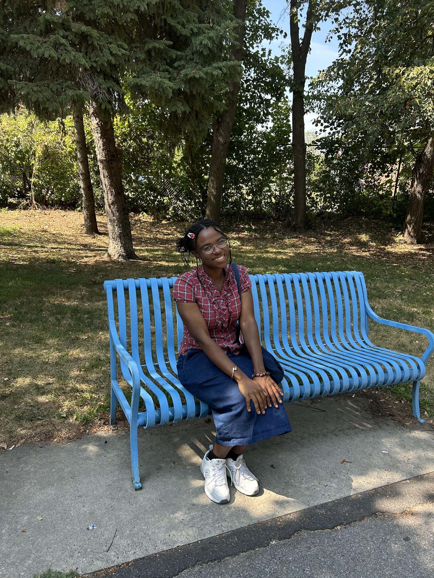 Jessica Bell About Me image. Sitting on a bench smiling.