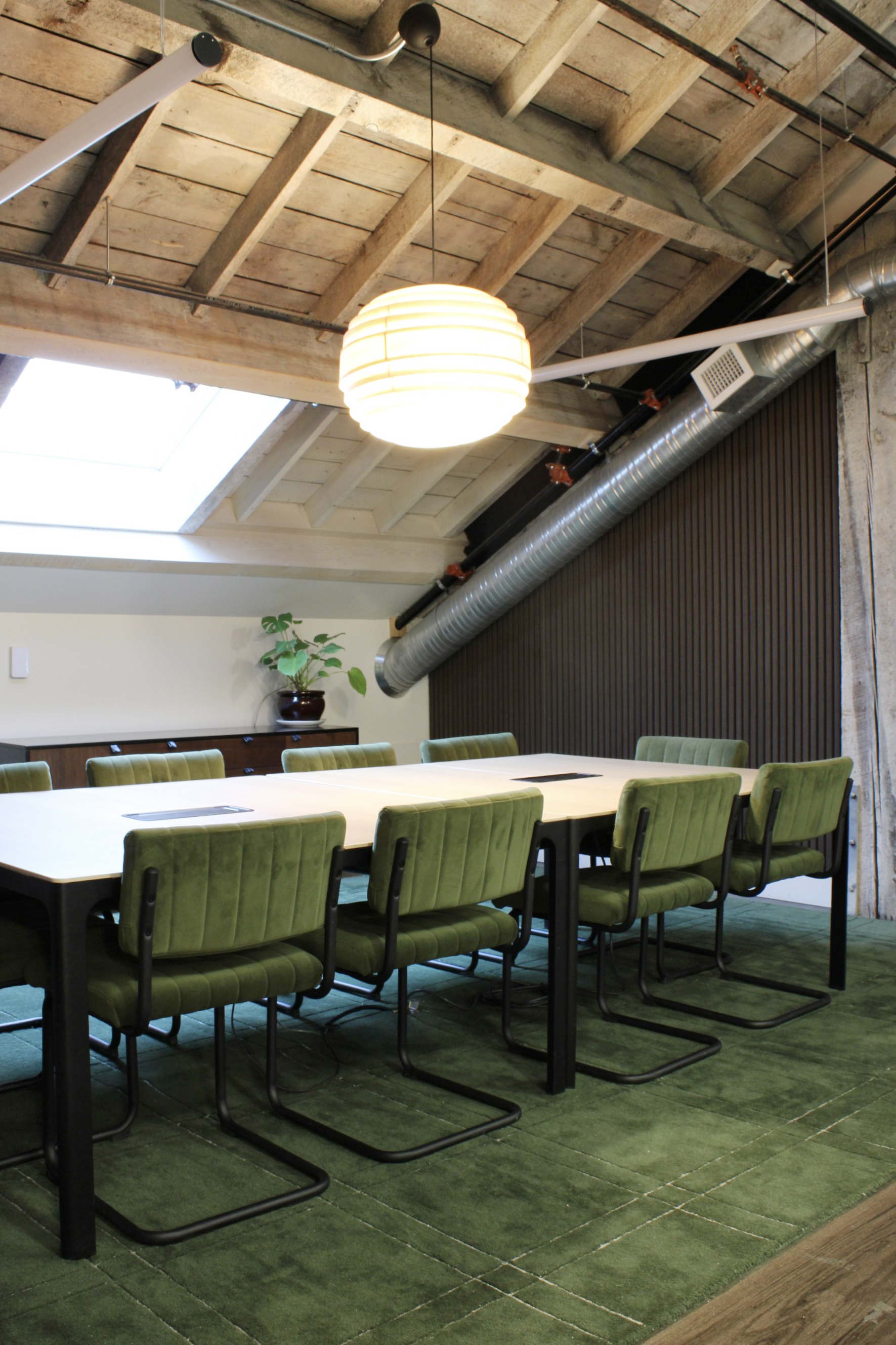 KWENCH boardroom with long table, chairs, skylight in a sloped attic roof.