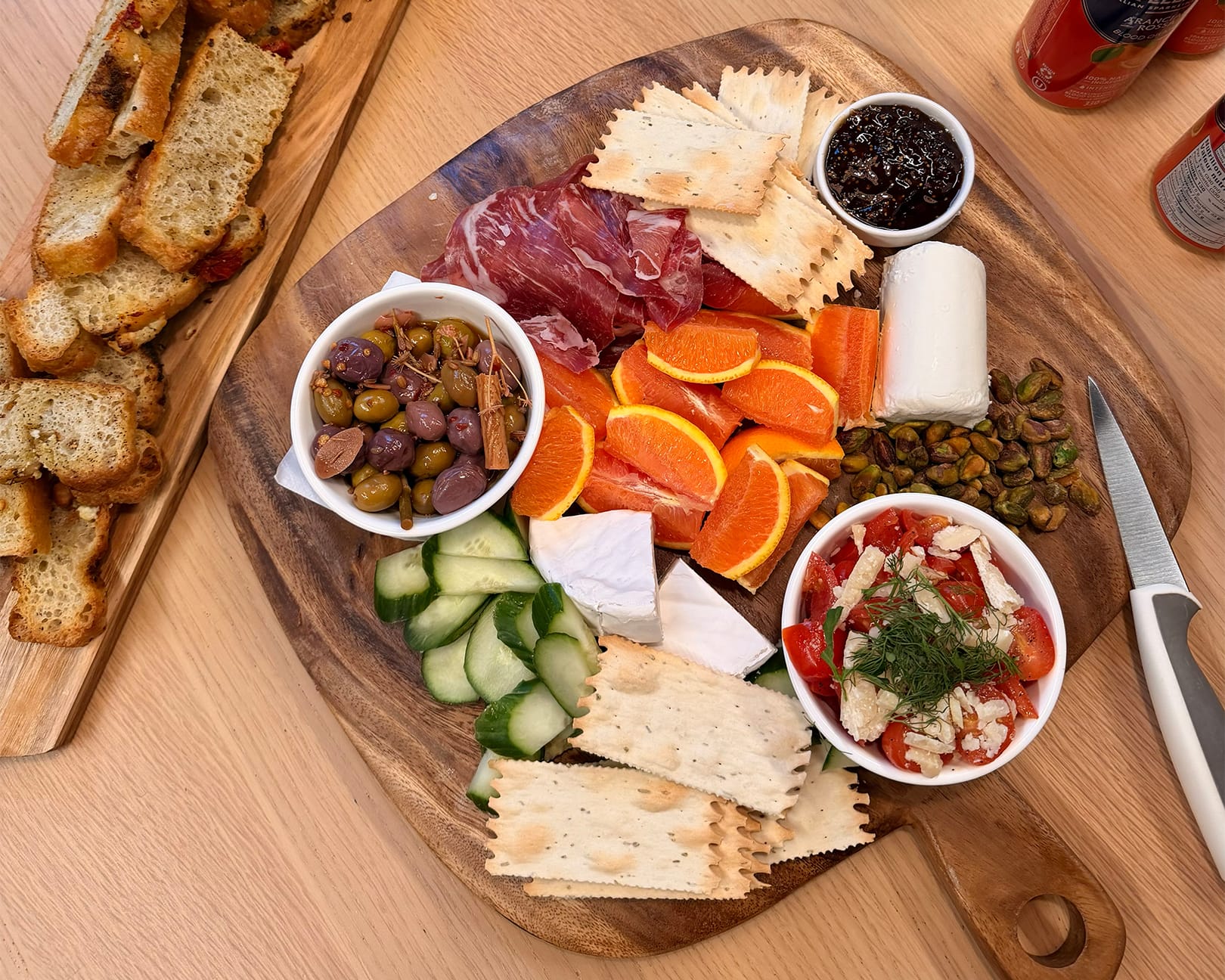 Charcuterie platter with olives, vegetables, nuts, prosciutto and fresh bread