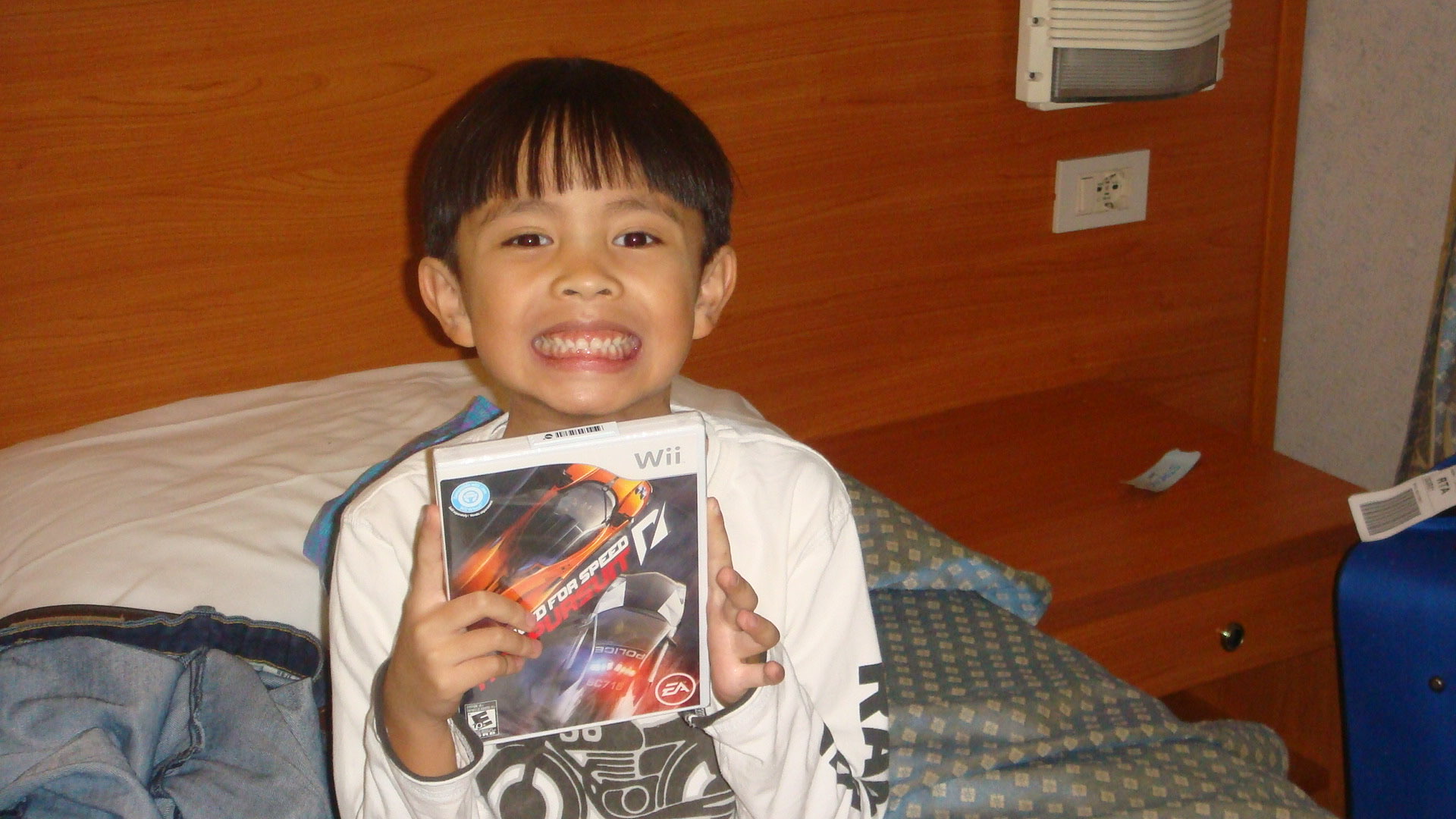 A picture of me in 2010, excited about receiving a Wii game: Need for Speed, Hot Pursuit, for Christmas.