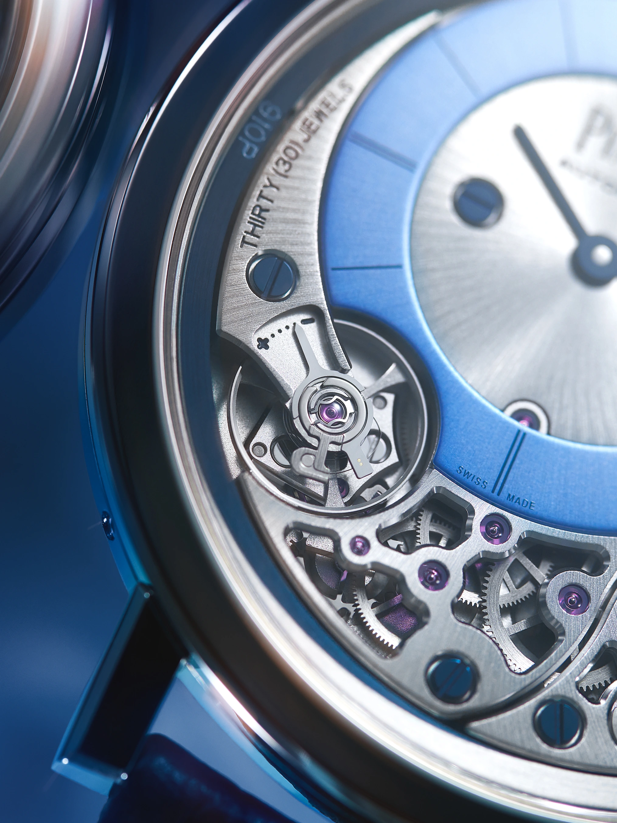Close-up of a Piaget watch movement through a sapphire case back, revealing a 30-jewel Swiss automatic calibre with an open-worked architecture. A blue sunburst dial and violet jewel settings are visible through the exhibition caseback.