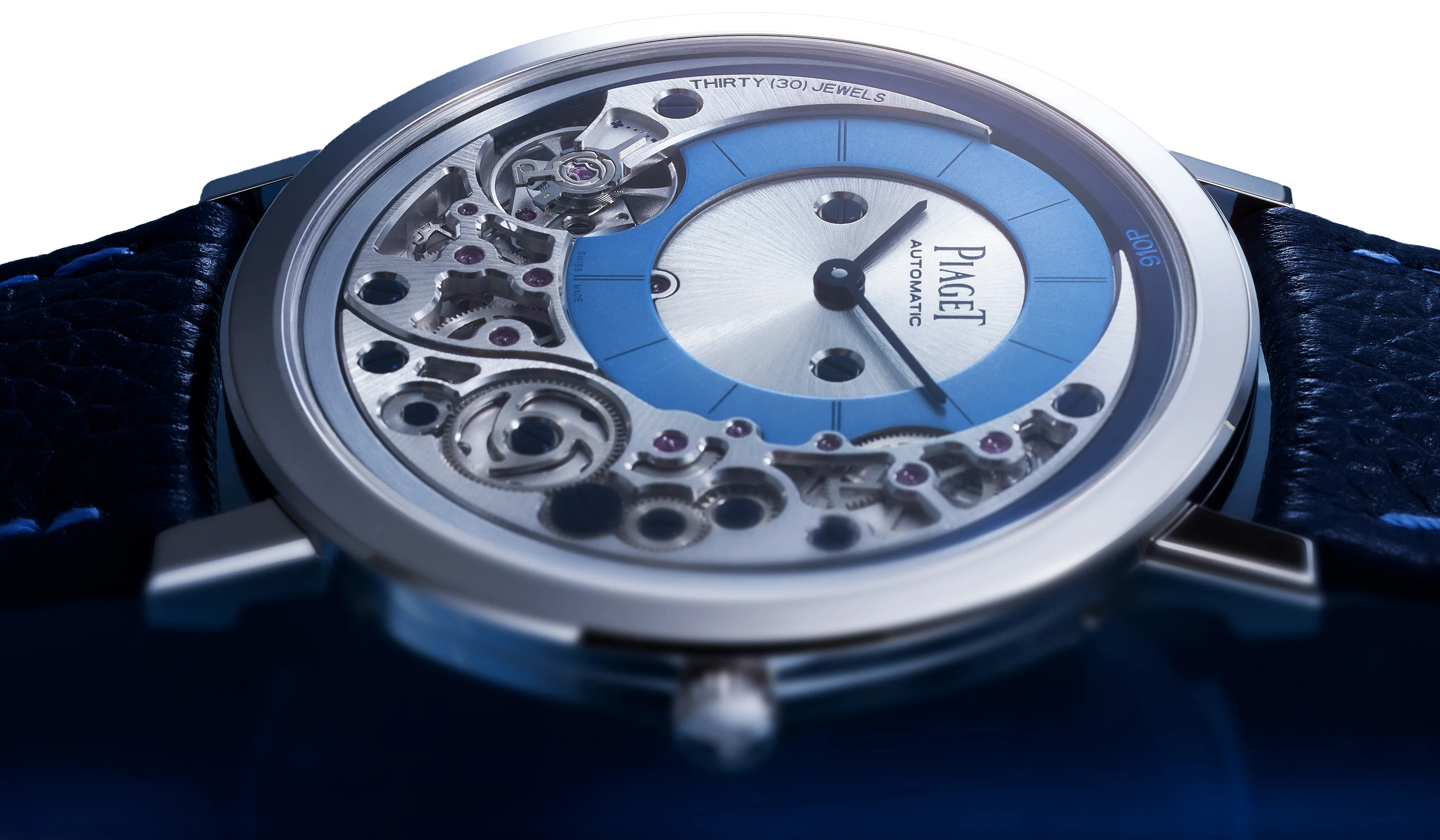 Close-up of the Piaget Altiplano 910P dial, showing the skeletonised automatic movement, blue sunray chapter ring, silver subsidiary dial and navy leather strap.