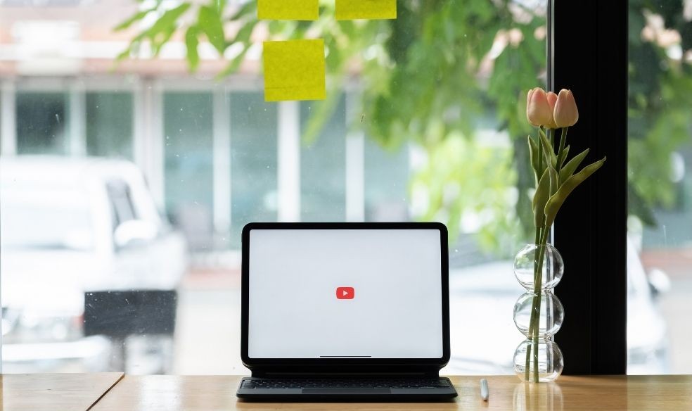 A laptop screen showing the YouTube logo.