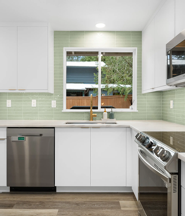 Modern kitchen remodel with white shaker cabinets, green tile backsplash, stainless steel appliances, and quartz countertops