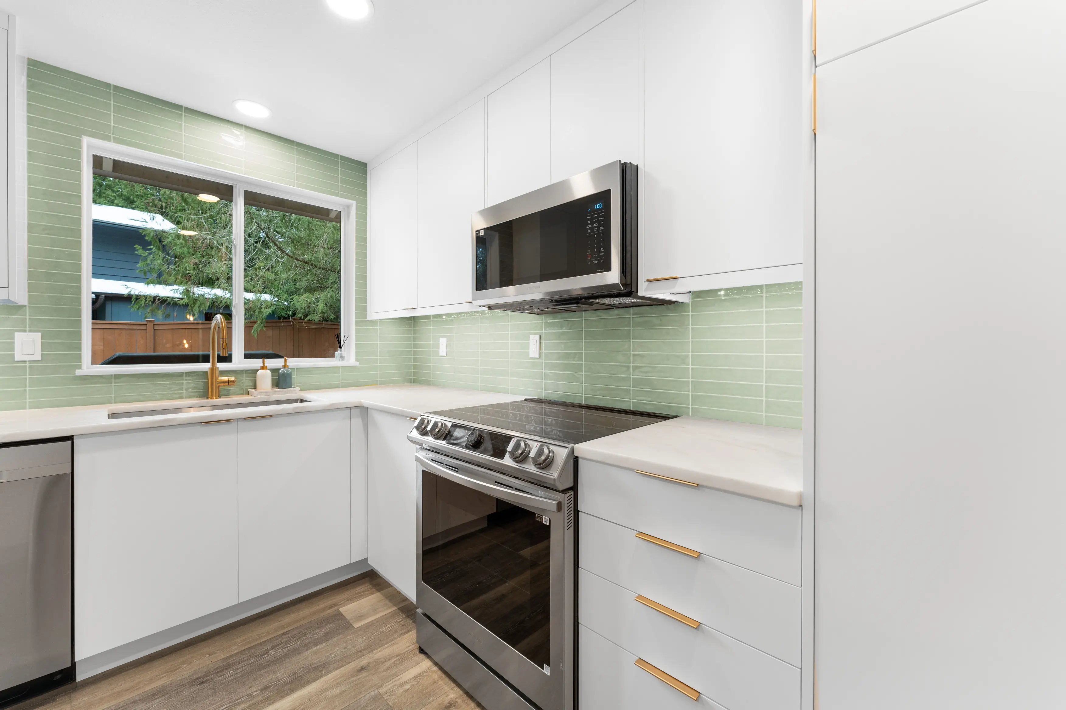 Modern kitchen with white cabinets, green tile backsplash