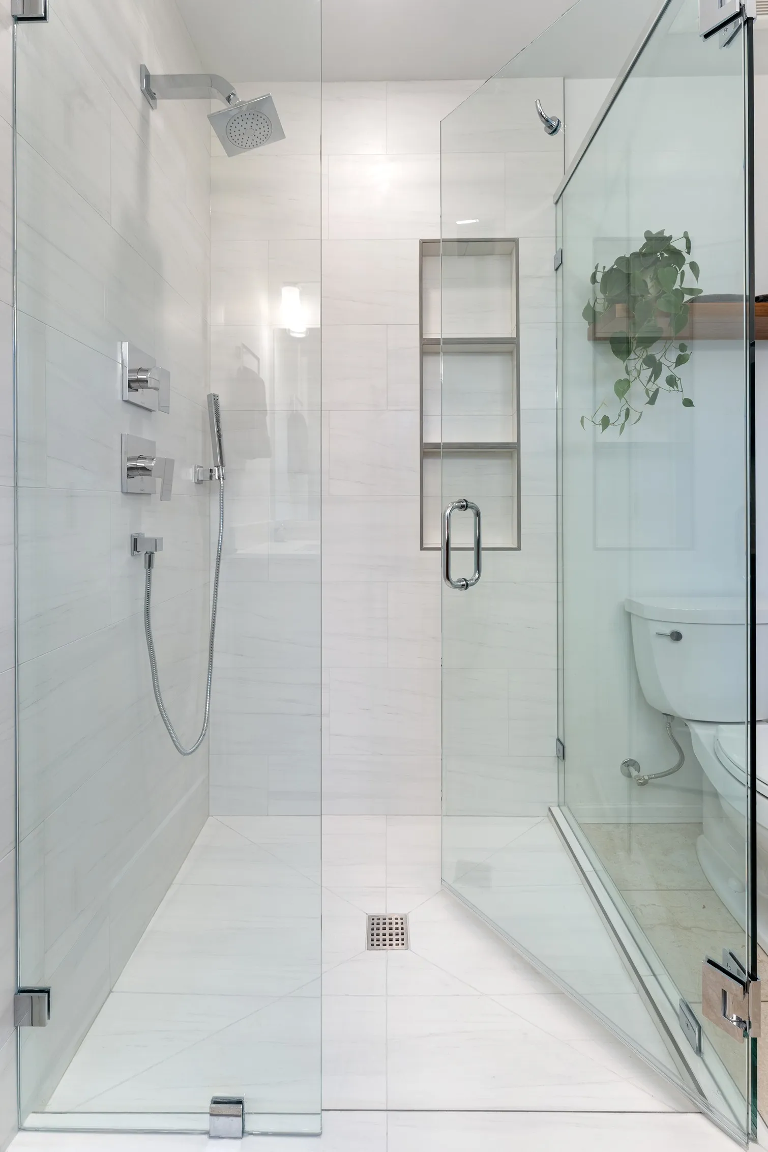 Walk-in shower with silver fixtures, a full glass enclosure, and large-format tile walls in a Bothell bathroom