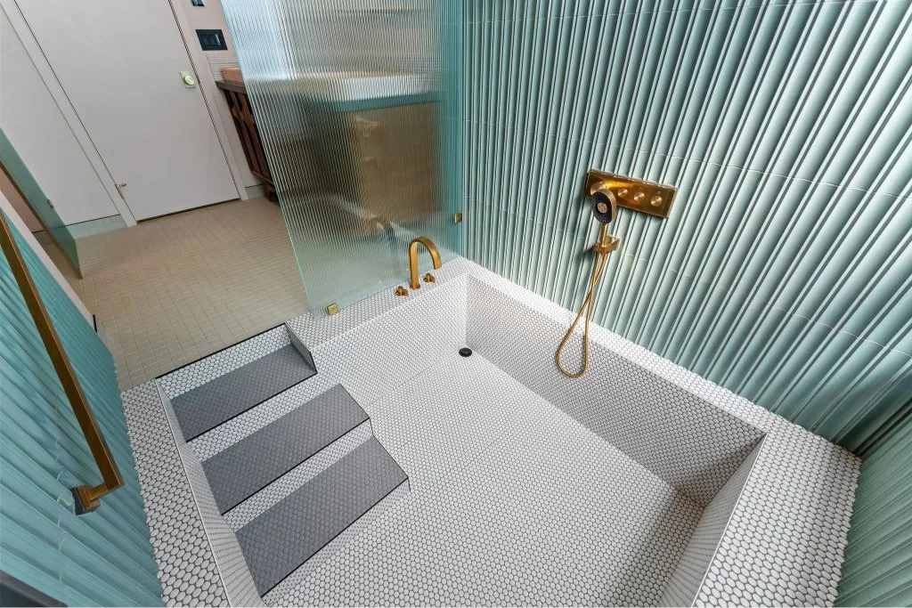 A walk-in shower with steps leading to the shower area in Bothell
