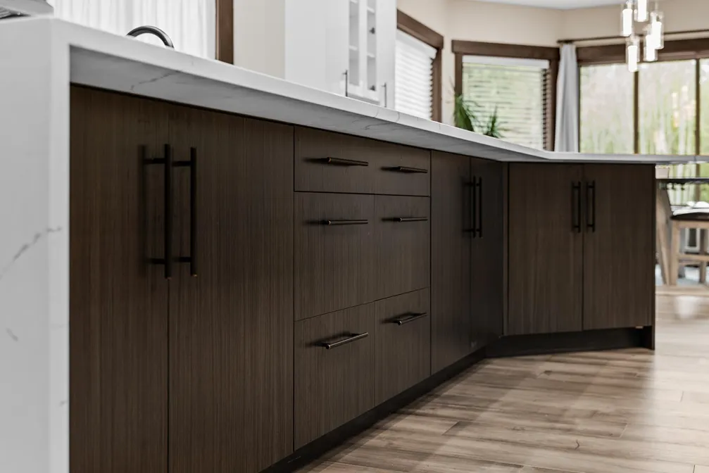 Dark wood-look stained lower kitchen island cabinets with black pull handles