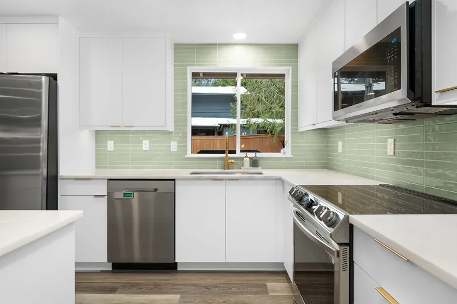 Modern white painted kitchen cabinets and drawers featuring brass hardware pulls