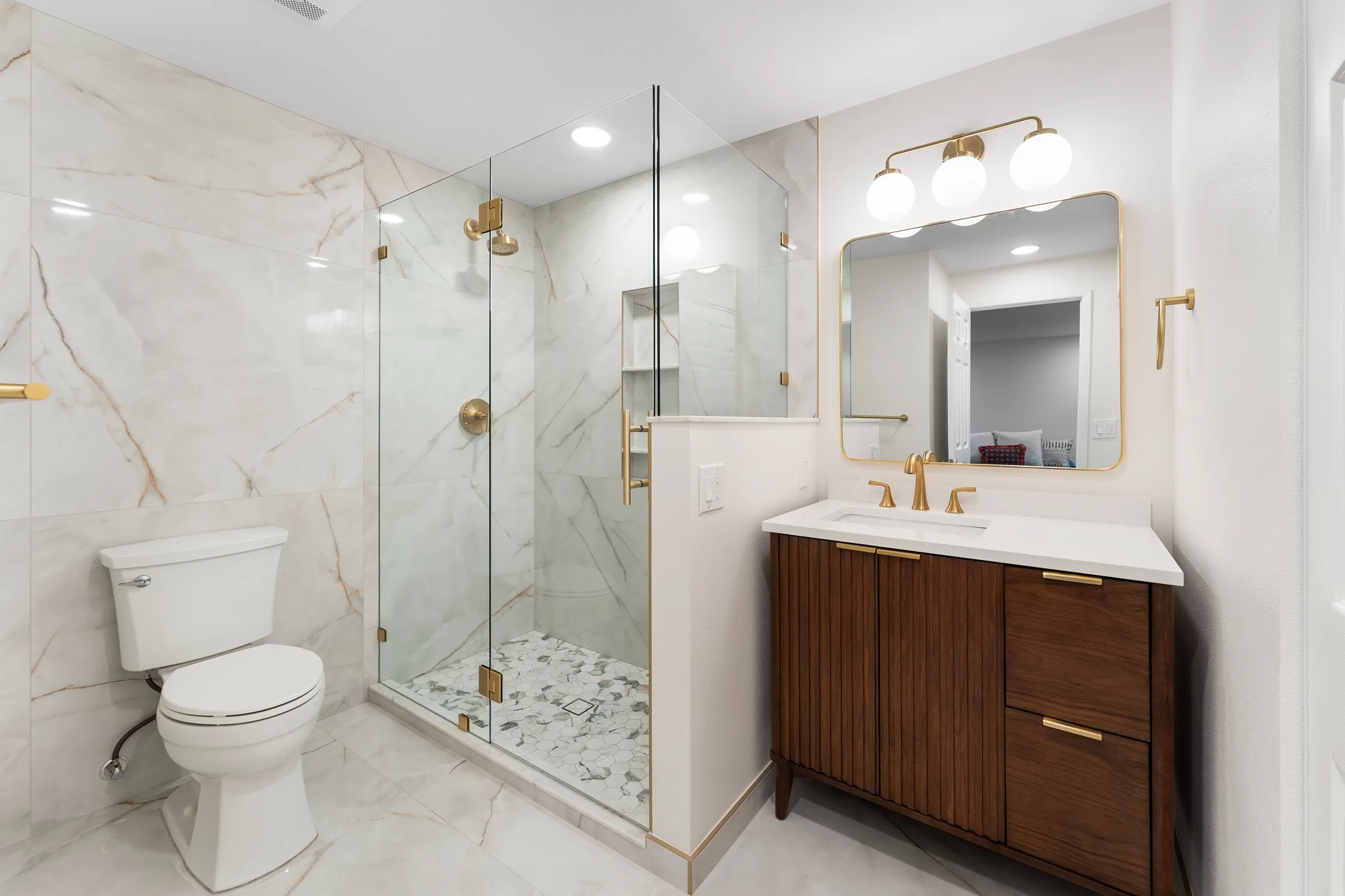 Large-format beige marble-veined wall and floor tiles paired with hexagon mosaic shower pan tiles