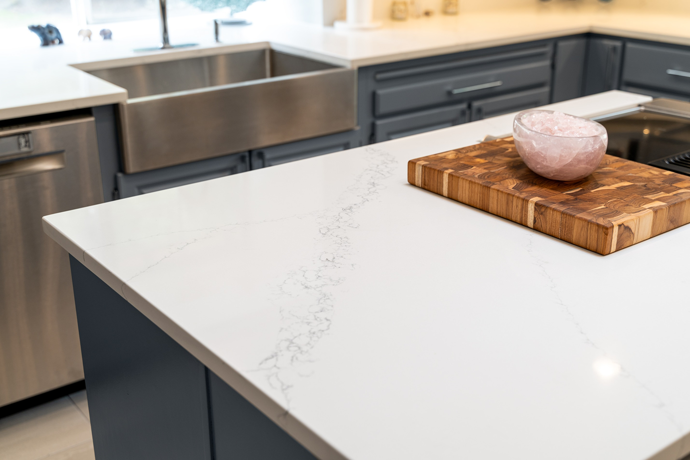 Close-up of a white calacatta quartz countertop with gold and amber veining on a kitchen island.