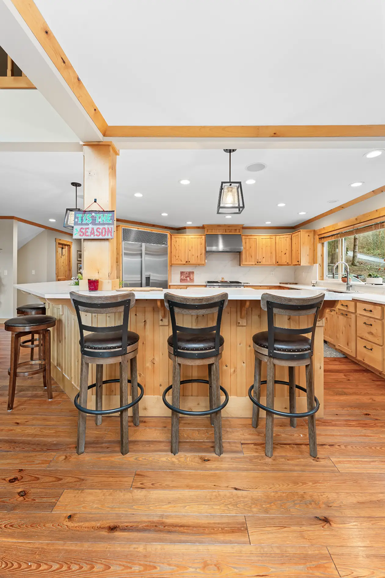  White quartz island countertop with a seating overhang and wood bar stools