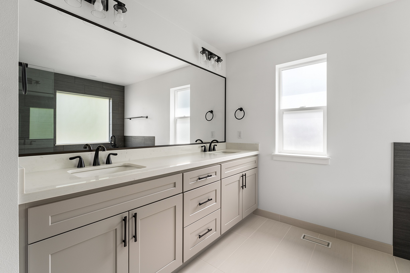 Dual-sink white quartz vanity countertop over light gray cabinetry.