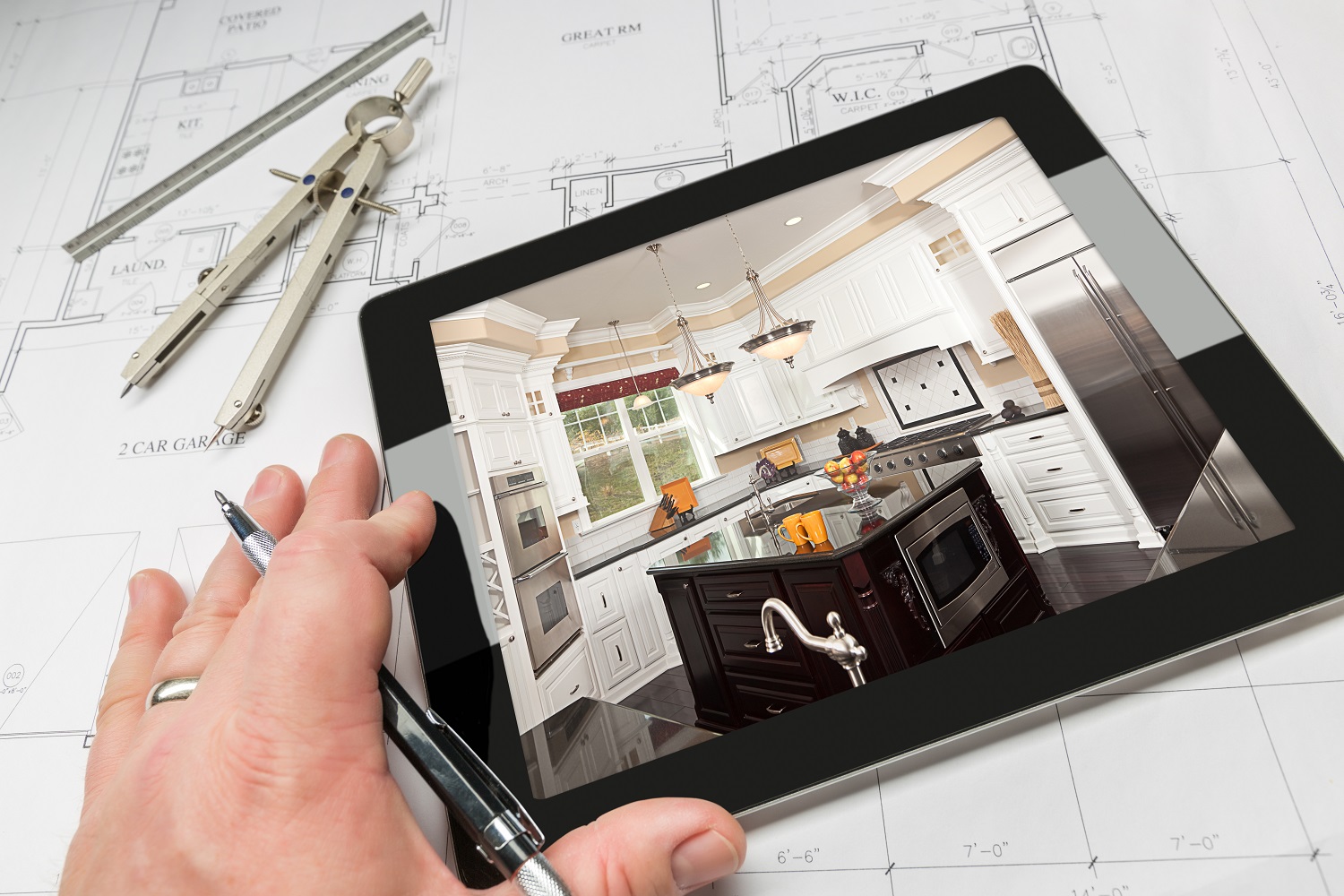 Kitchen design on a tablet with architectural blueprint and compass