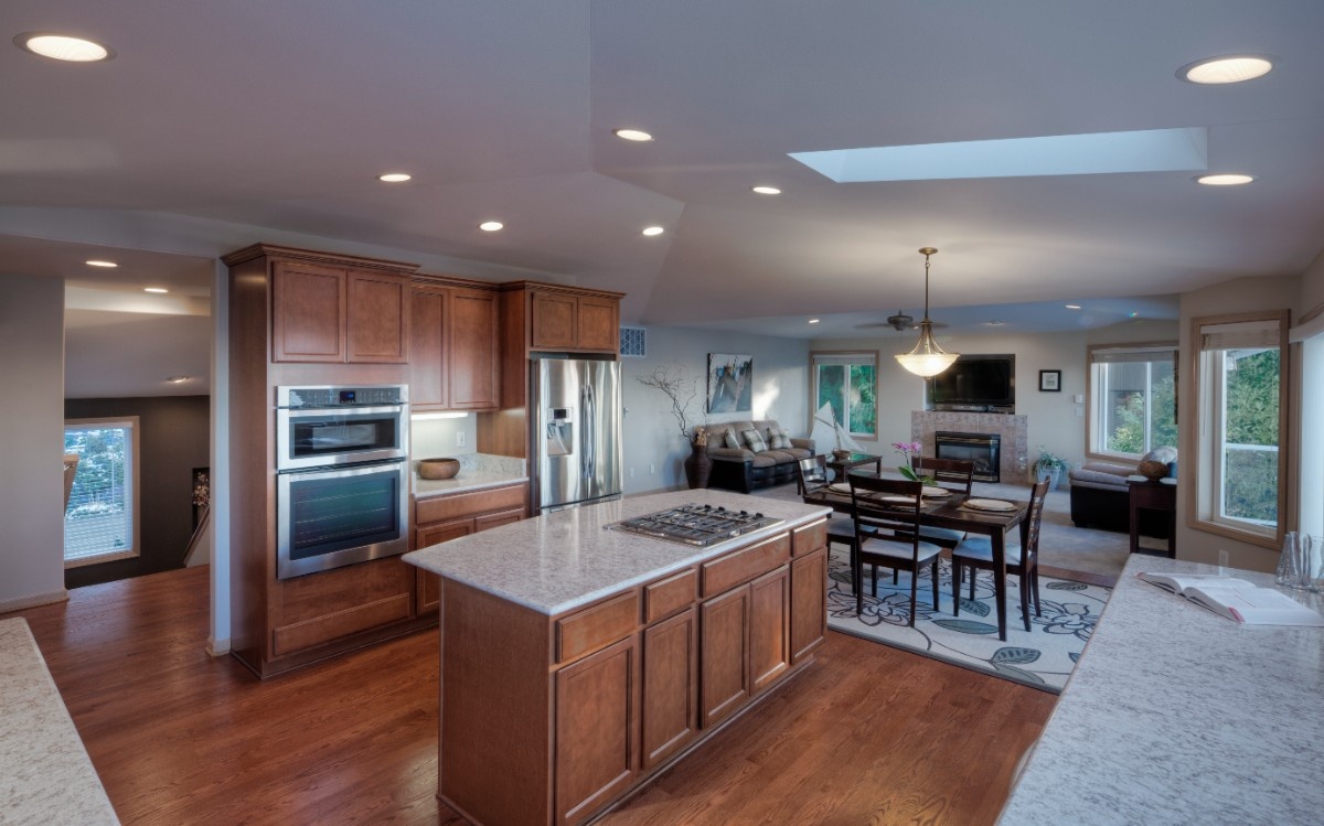 Open concept kitchen remodel with island facing an adjacent living room