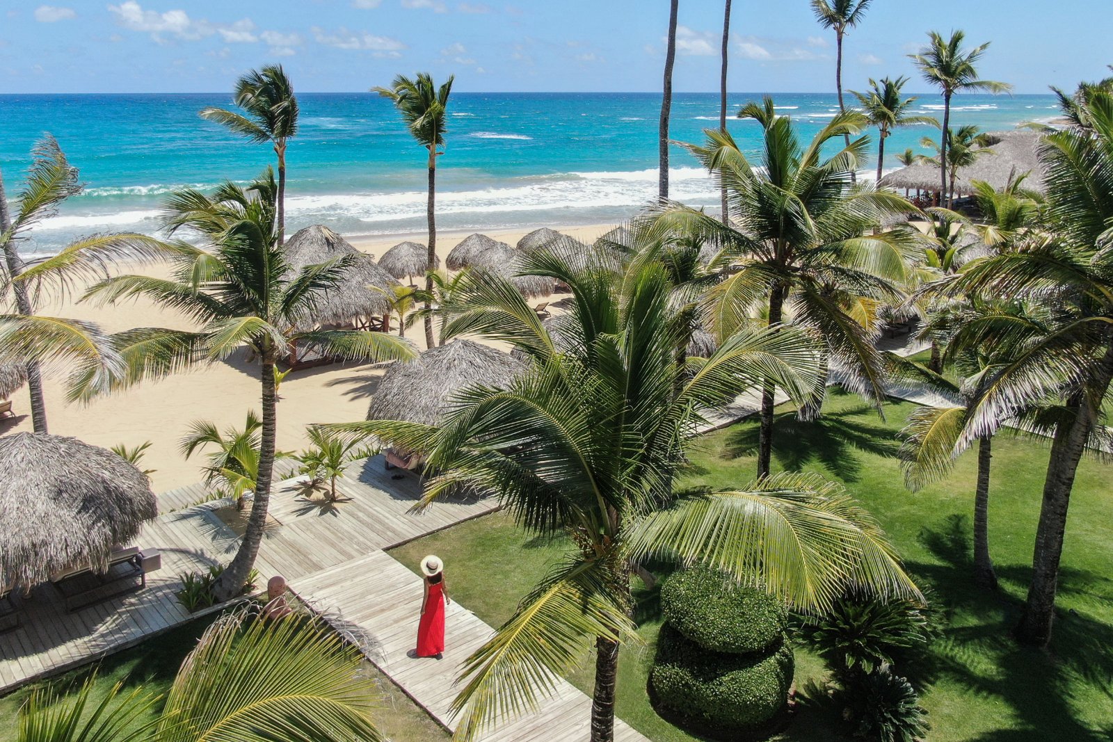 Het strand van het resort met palmen en rieten parasols