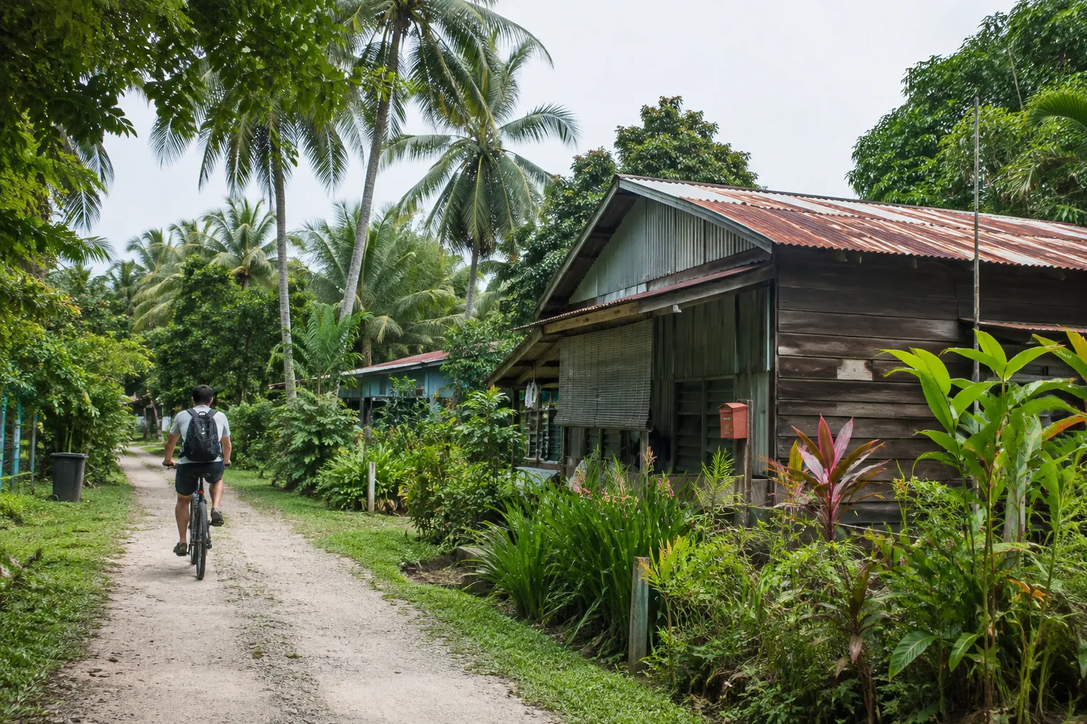 Fietser langs een oud houten huis op Pulau Ubin, Singapore
