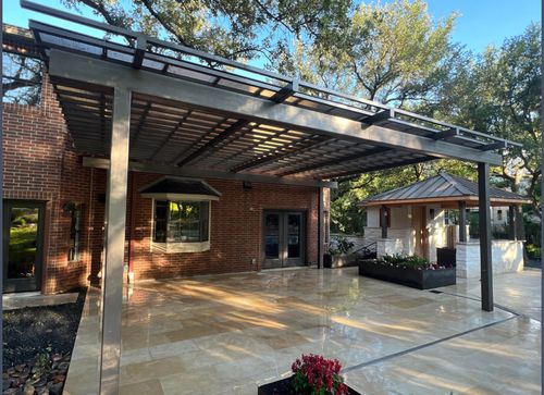 Spacious backyard pergola with overhead cover and built-in outdoor kitchen by Angels View Construction