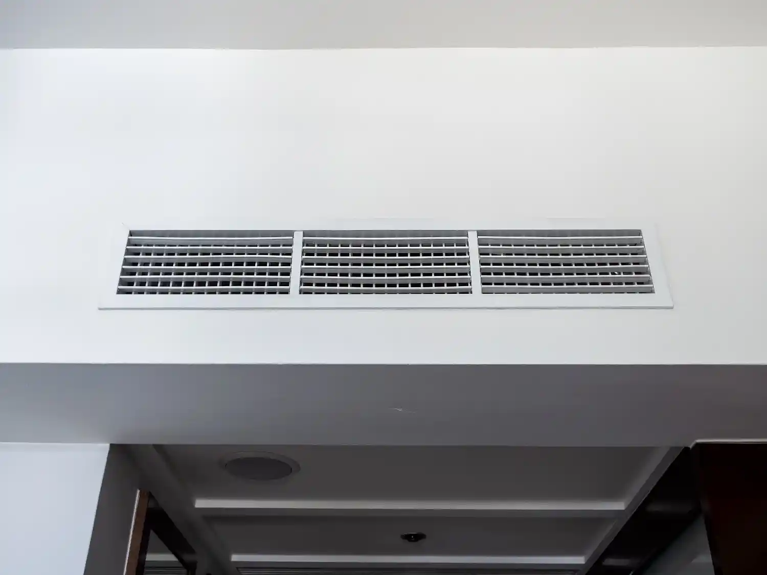 Long white ceiling air vent grille.