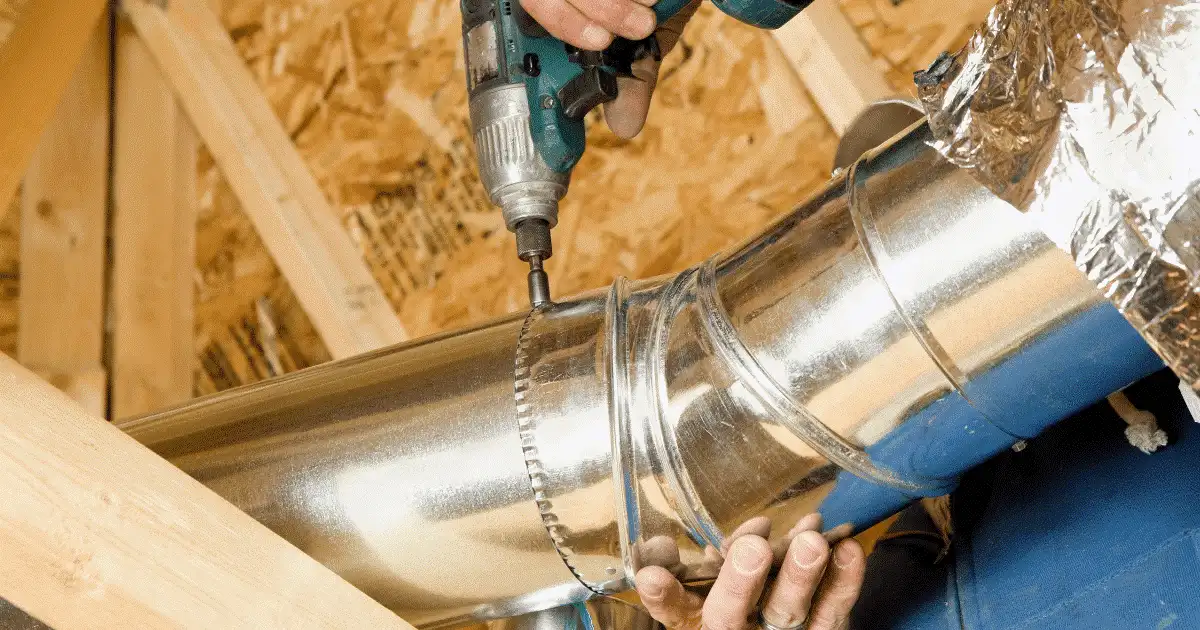 Installing metal air duct with a drill.