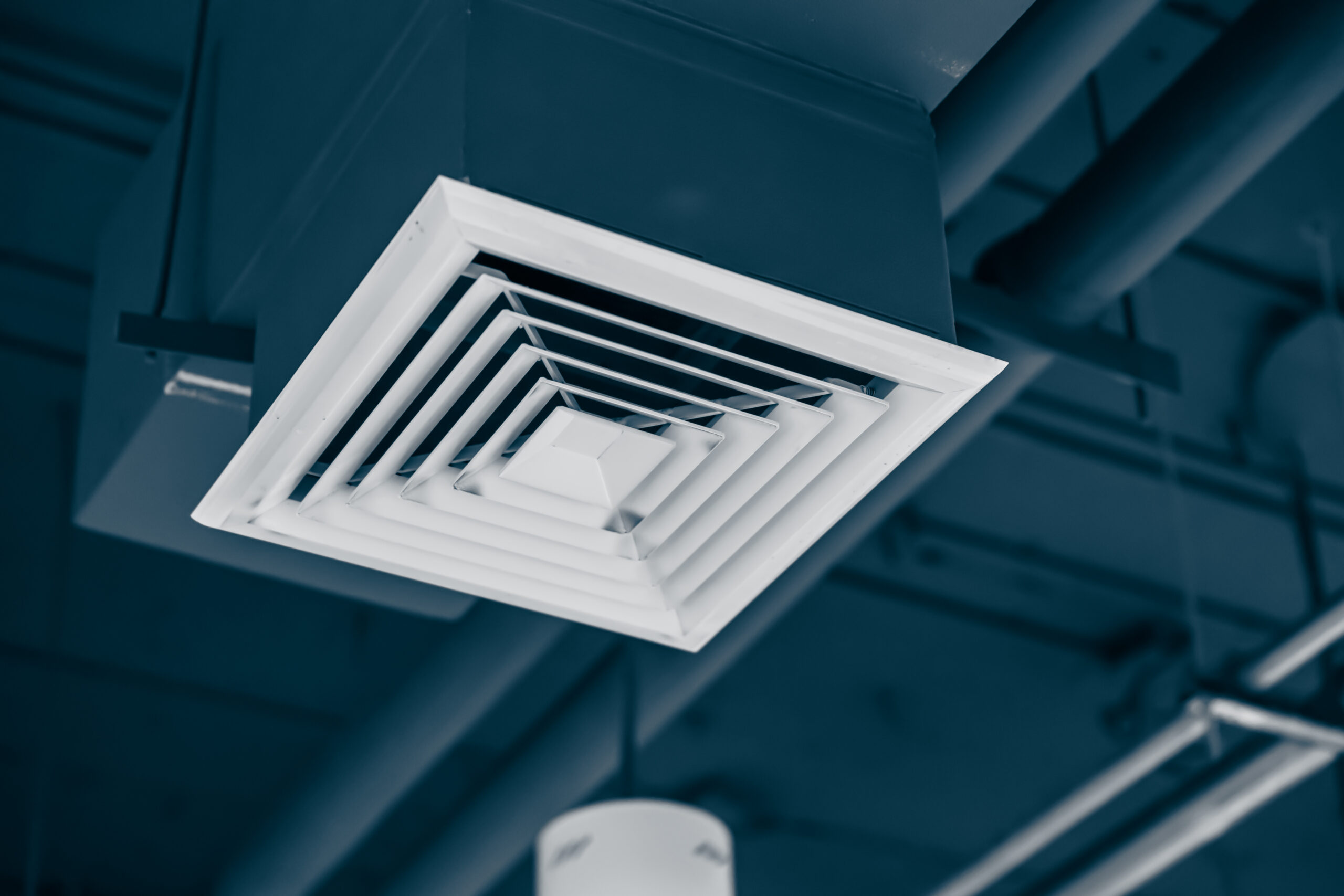 White ceiling air supply diffuser in ductwork.