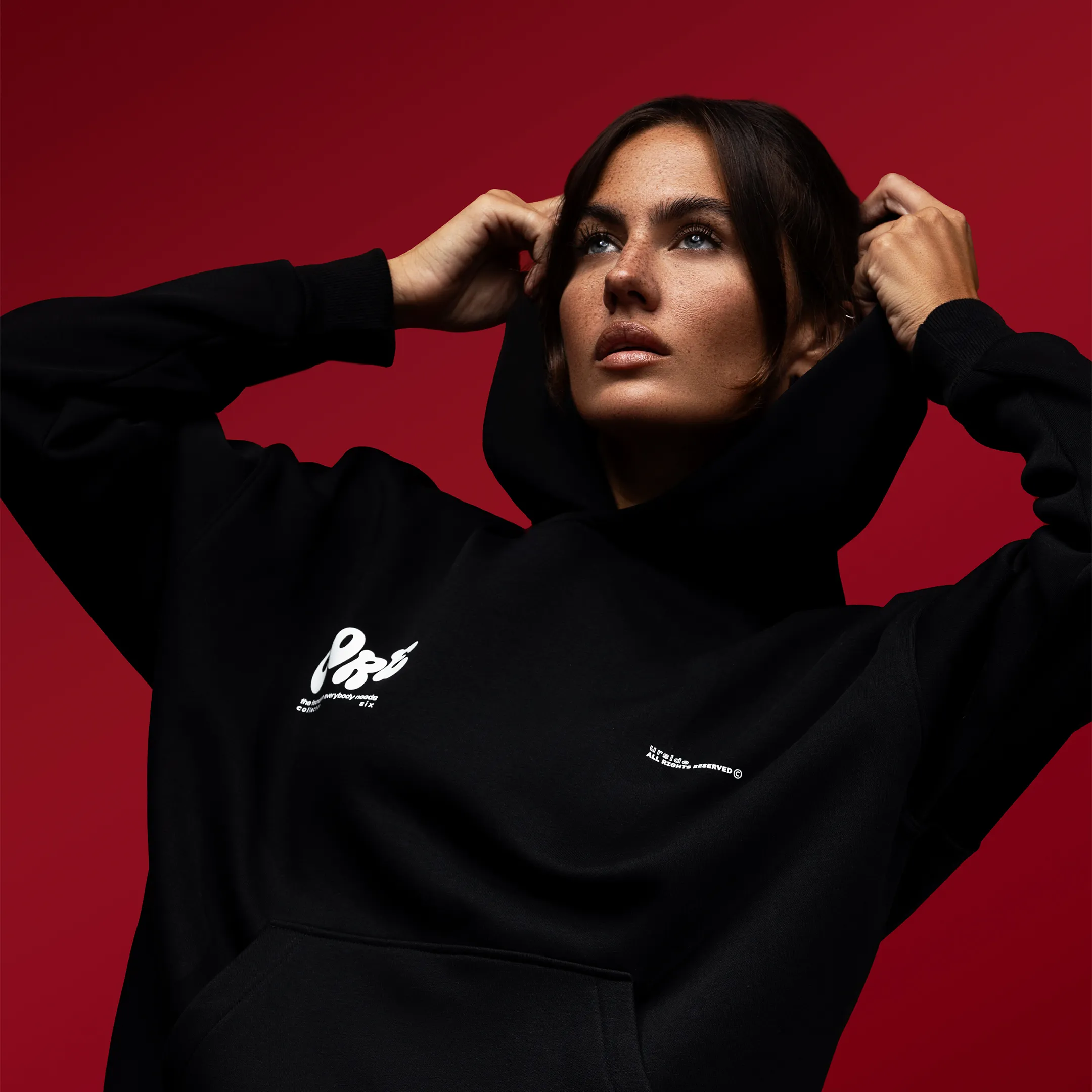 Eine Dame mit schwarzem Pullover vor einem roten Hintergrund