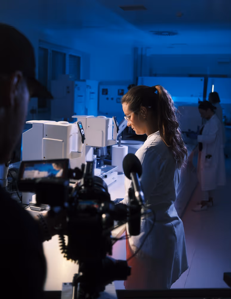 Eine Frau in einem Labor vor einer Kamera