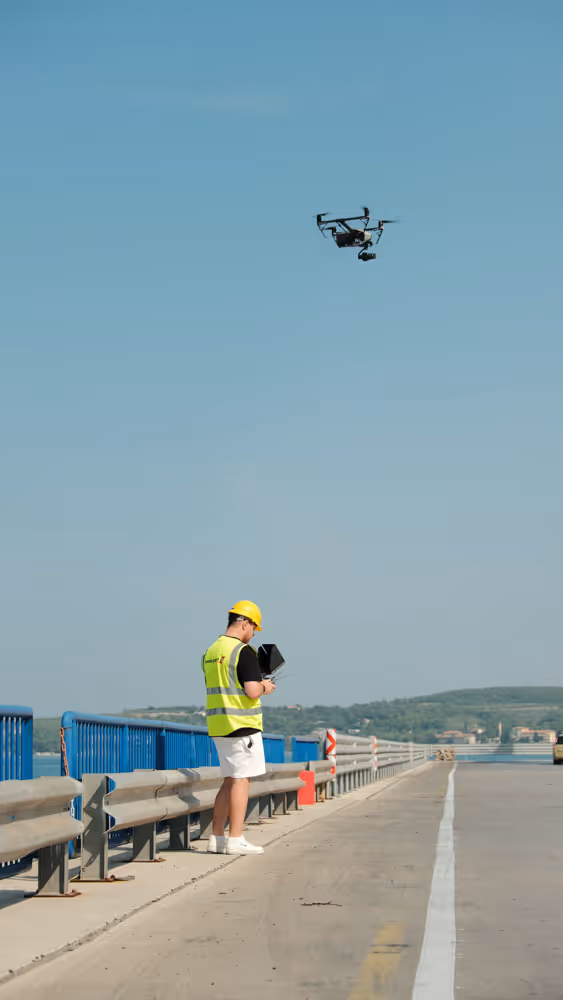 Ein Mann unter einer Drohne mit einer Warnweste