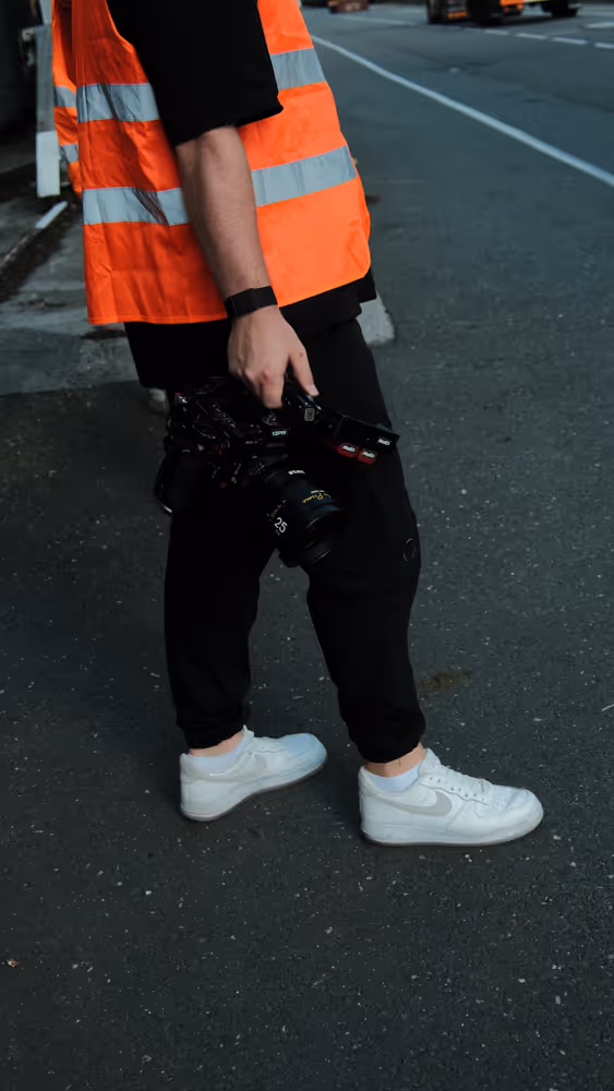 Ein Mann mit einer Kamera und einer Warnweste