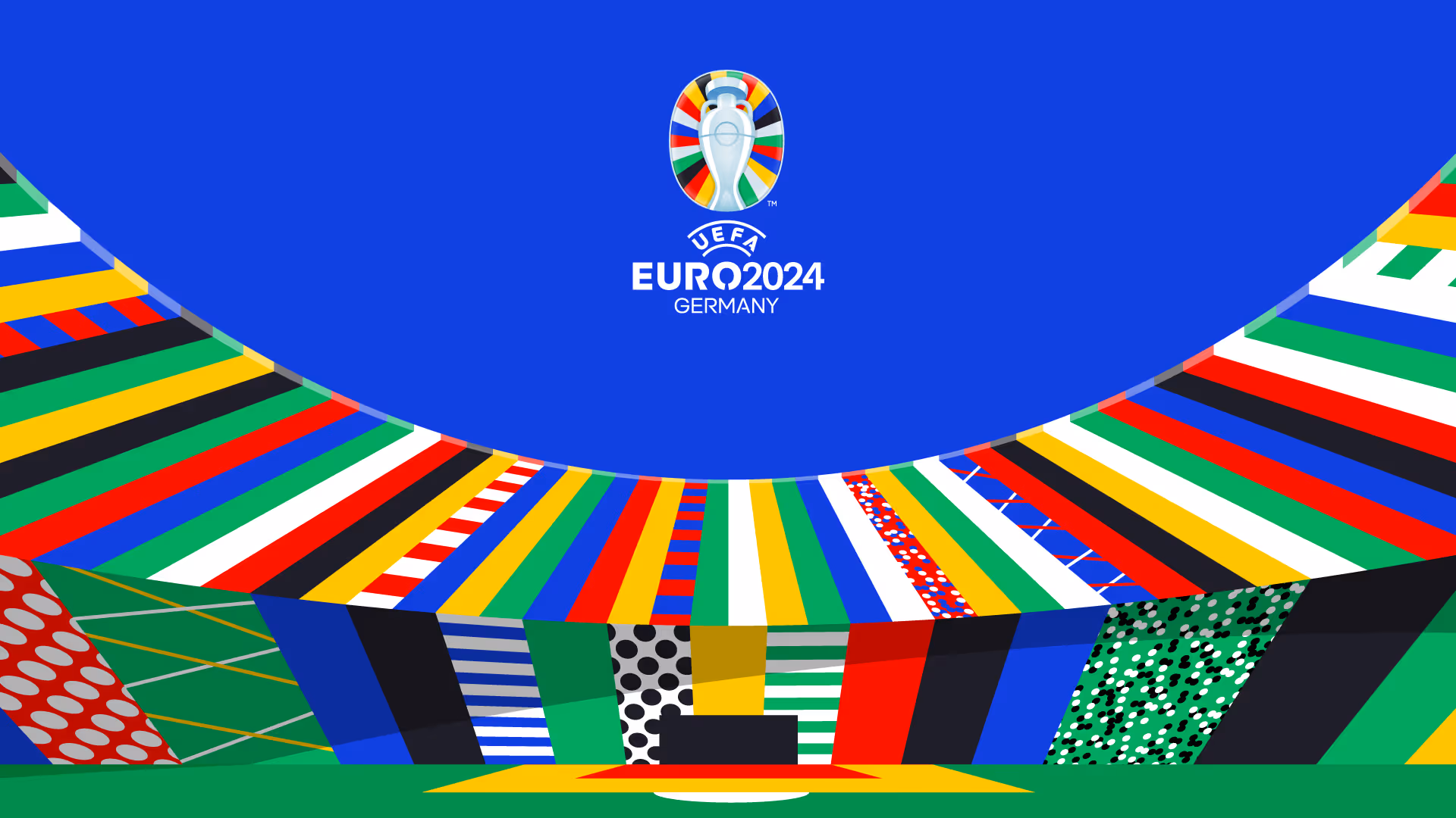UEFA EURO 2024 Logo mit einem stilisierten Fußballstadion in bunten Farben und Mustern unter einem blauen Himmel.