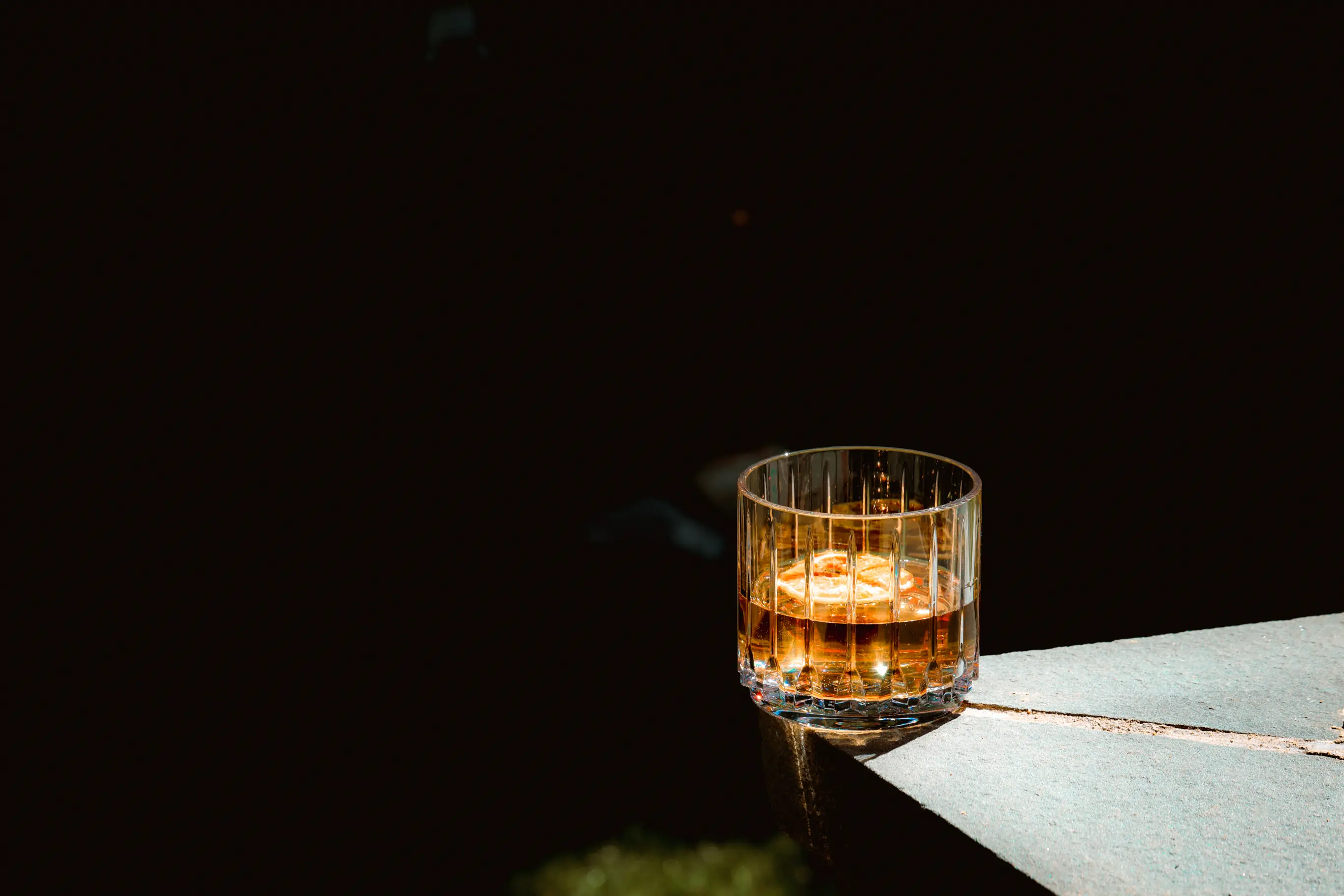 An old fashioned Bold Drinkware Tryst Old Fashioned glass on a stone shelf