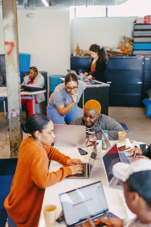 Several people collaborating on a project around a table. 