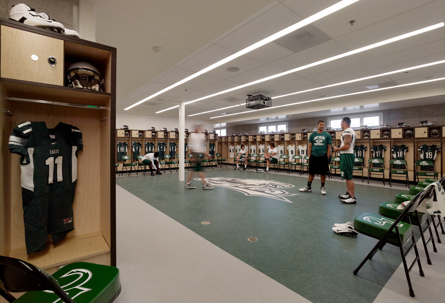 football locker room with athletes standing