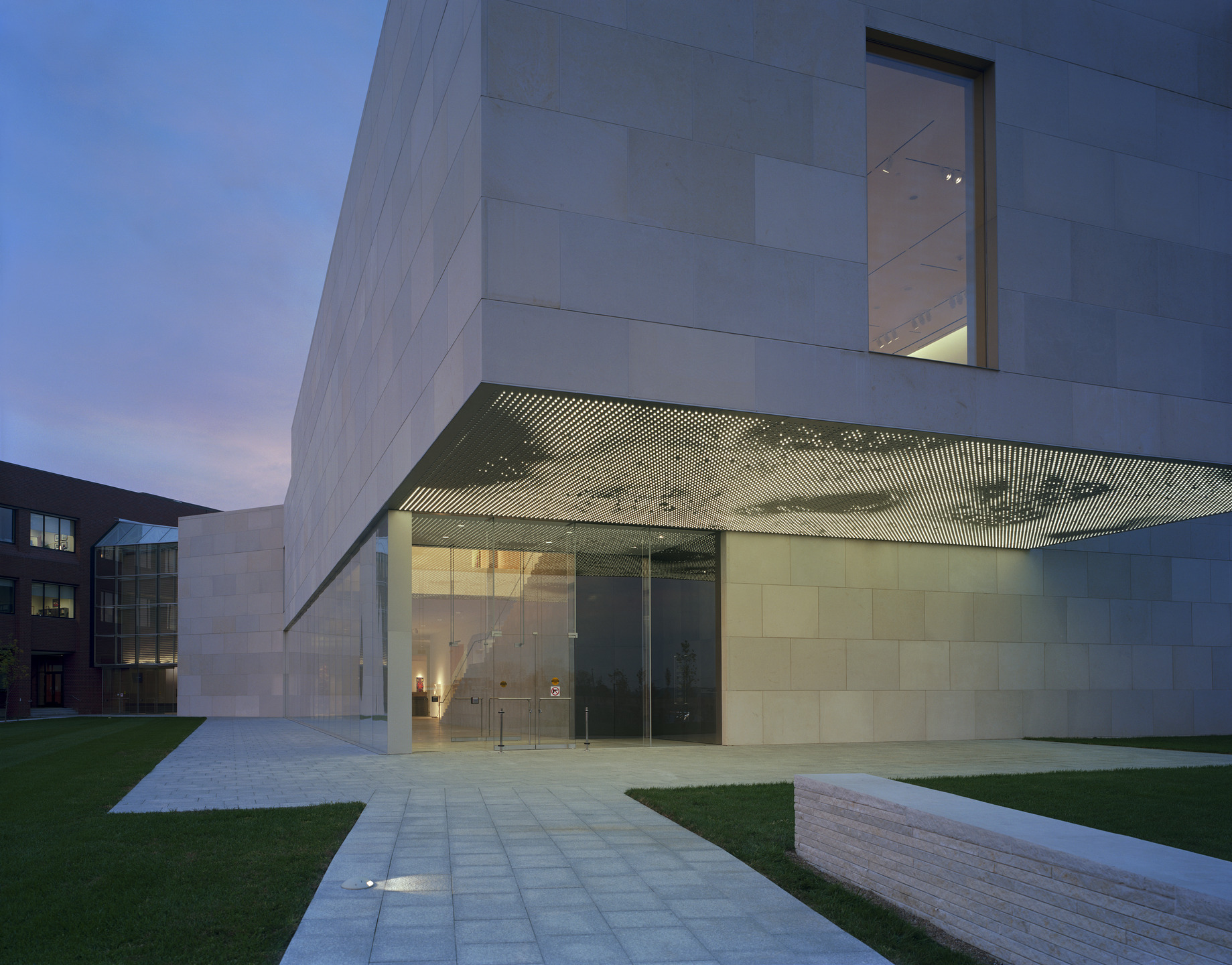 The underside of a limestone cantilever is illuminated with and LED art fixture.