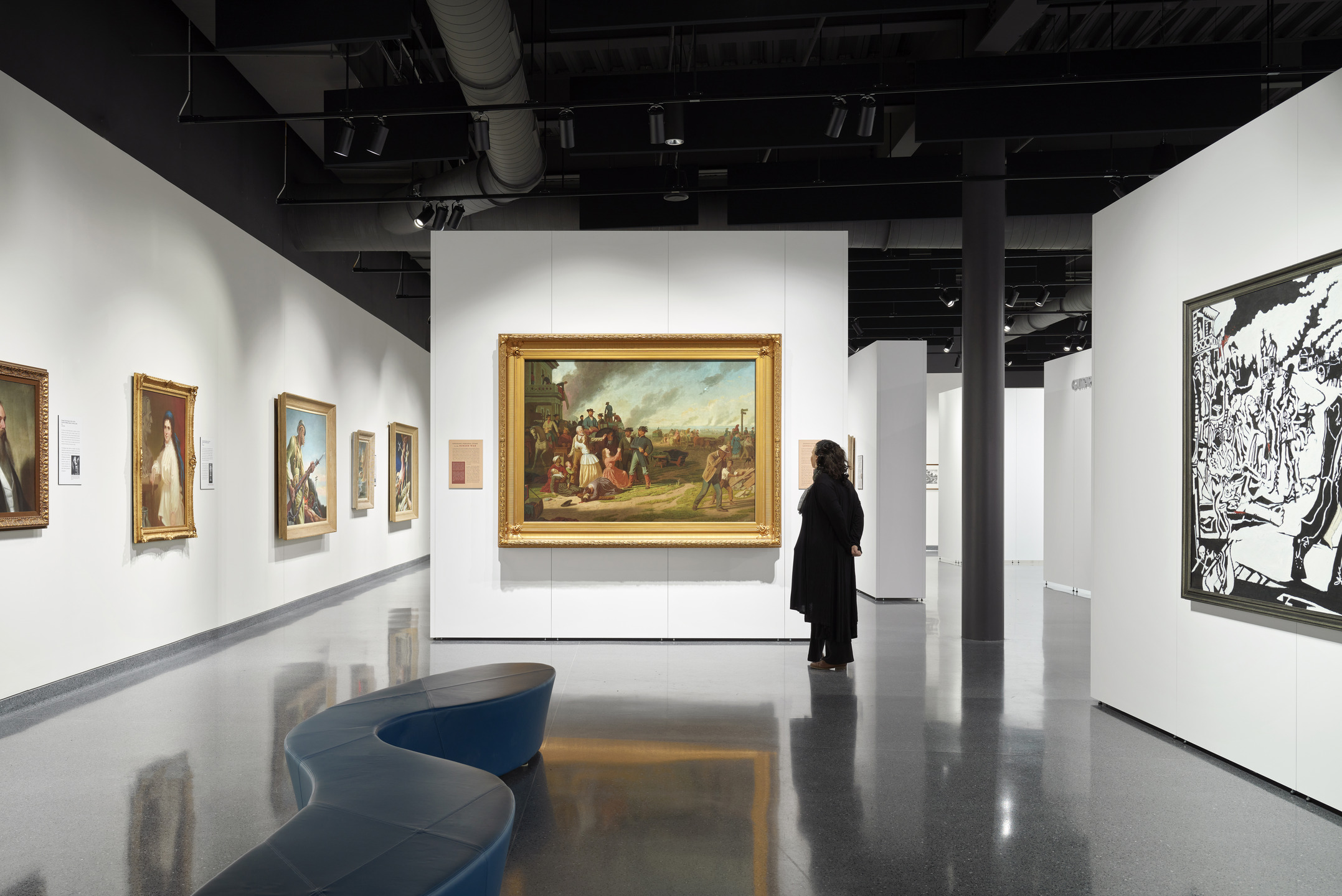 A person views an artwork in a gallery space.