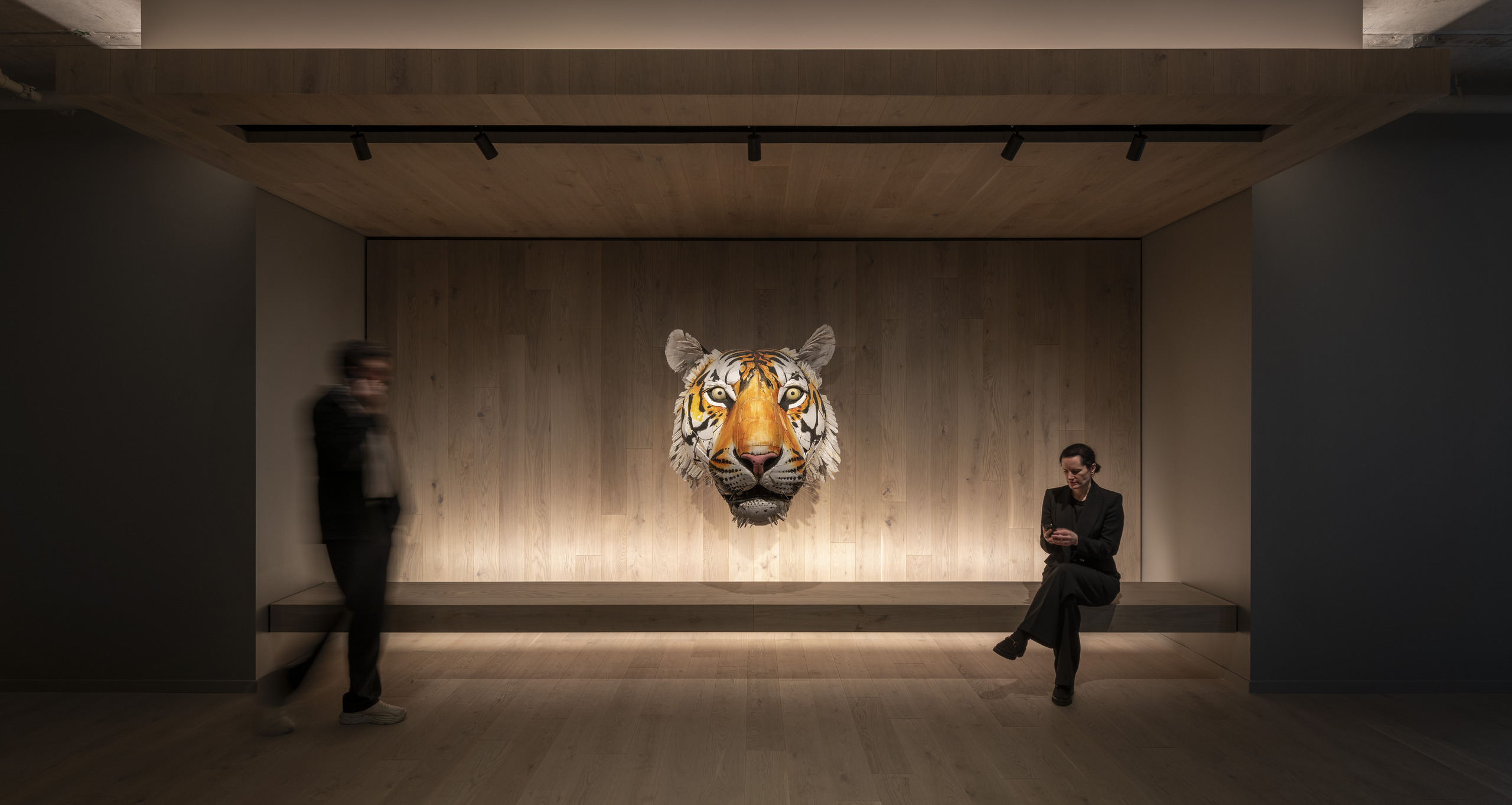 A tiger head sculpture offers a dramatic backdrop to a recessed bench.