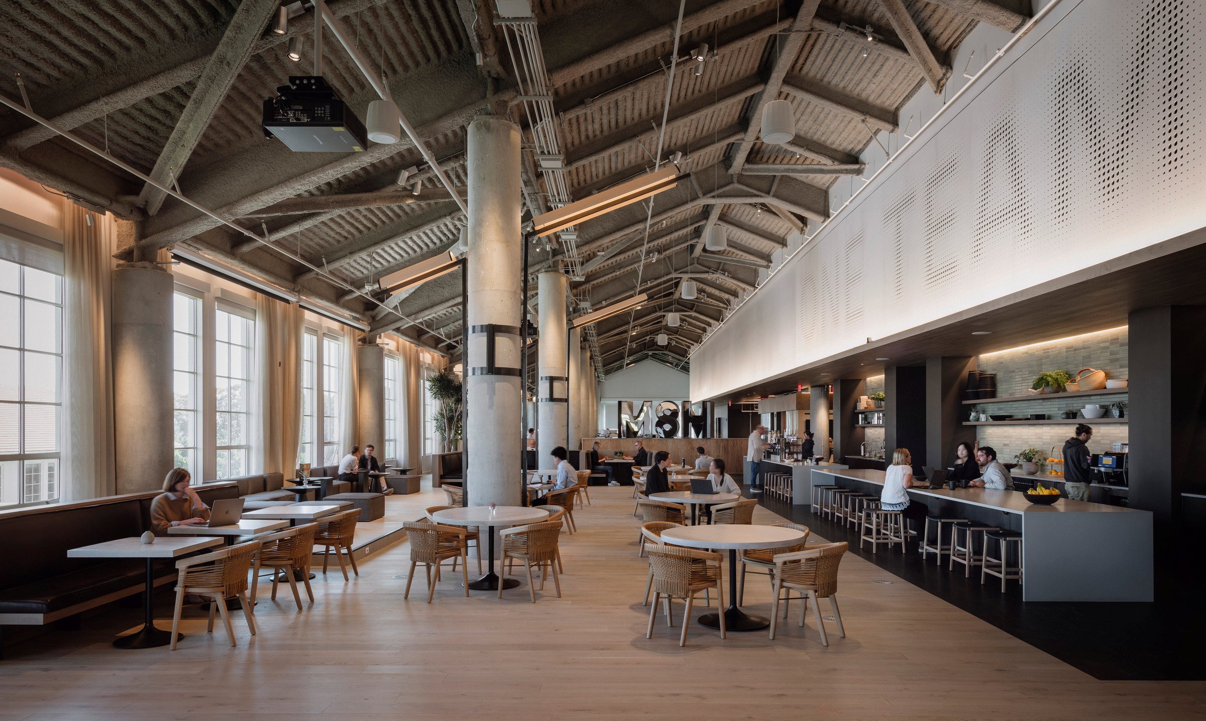 A high-ceilinged cafe offers employees a unique workspace that doubles as a chic coffee spot.