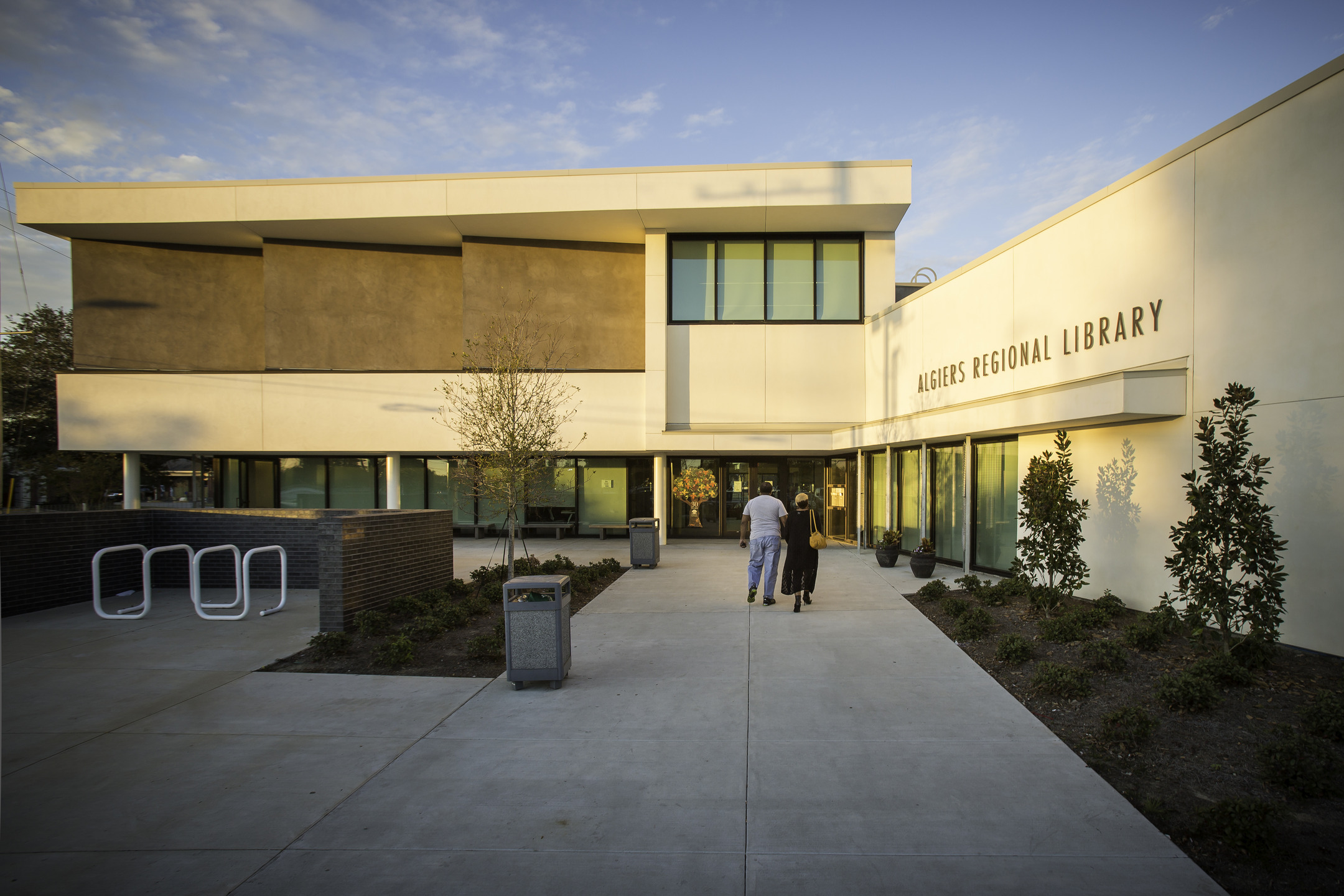 Two people walk up to the entrance of the Algiers Regional Library