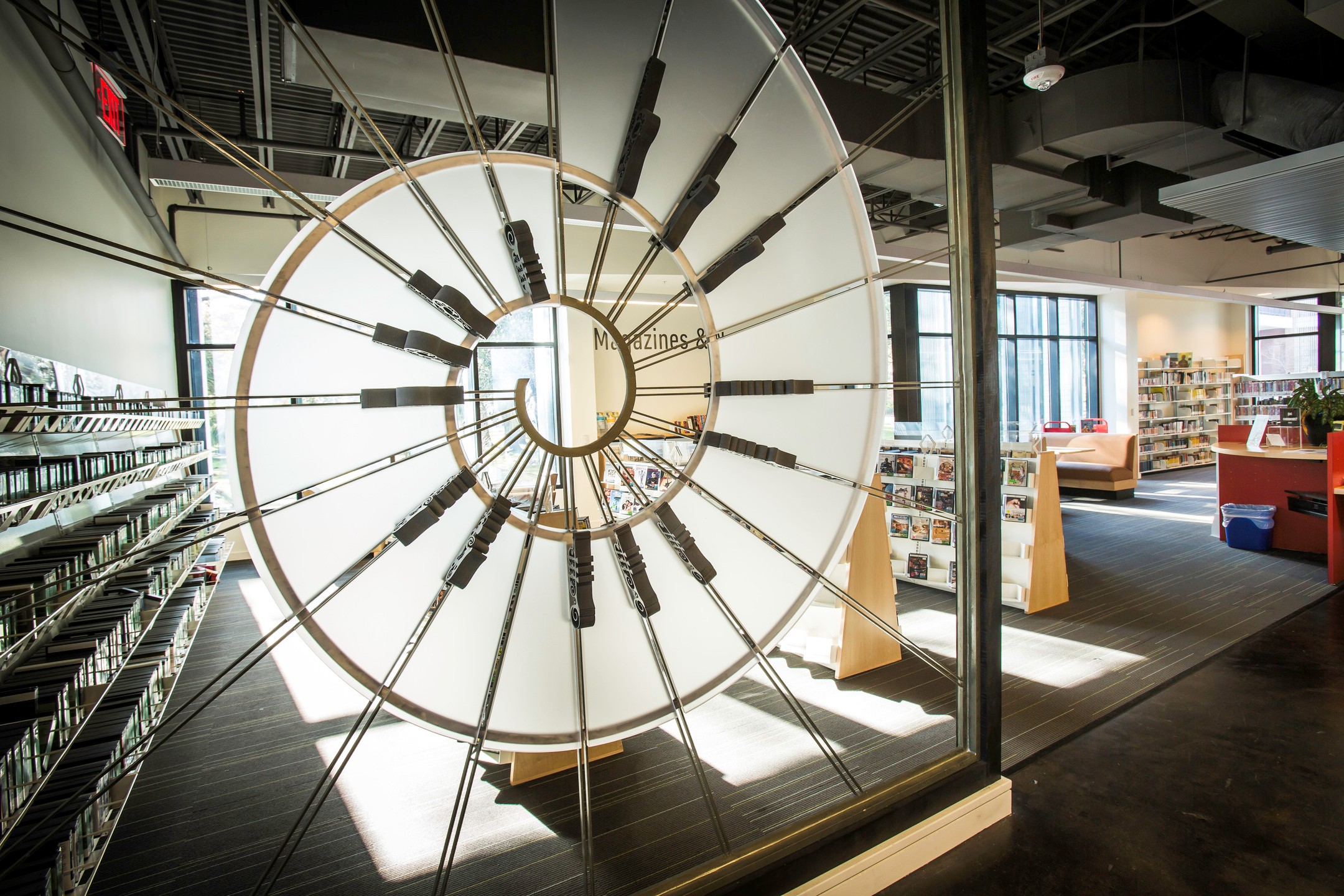 A spiral-shaped art piece made of cables, metal, and opaque plastic offers a unique space divider. 