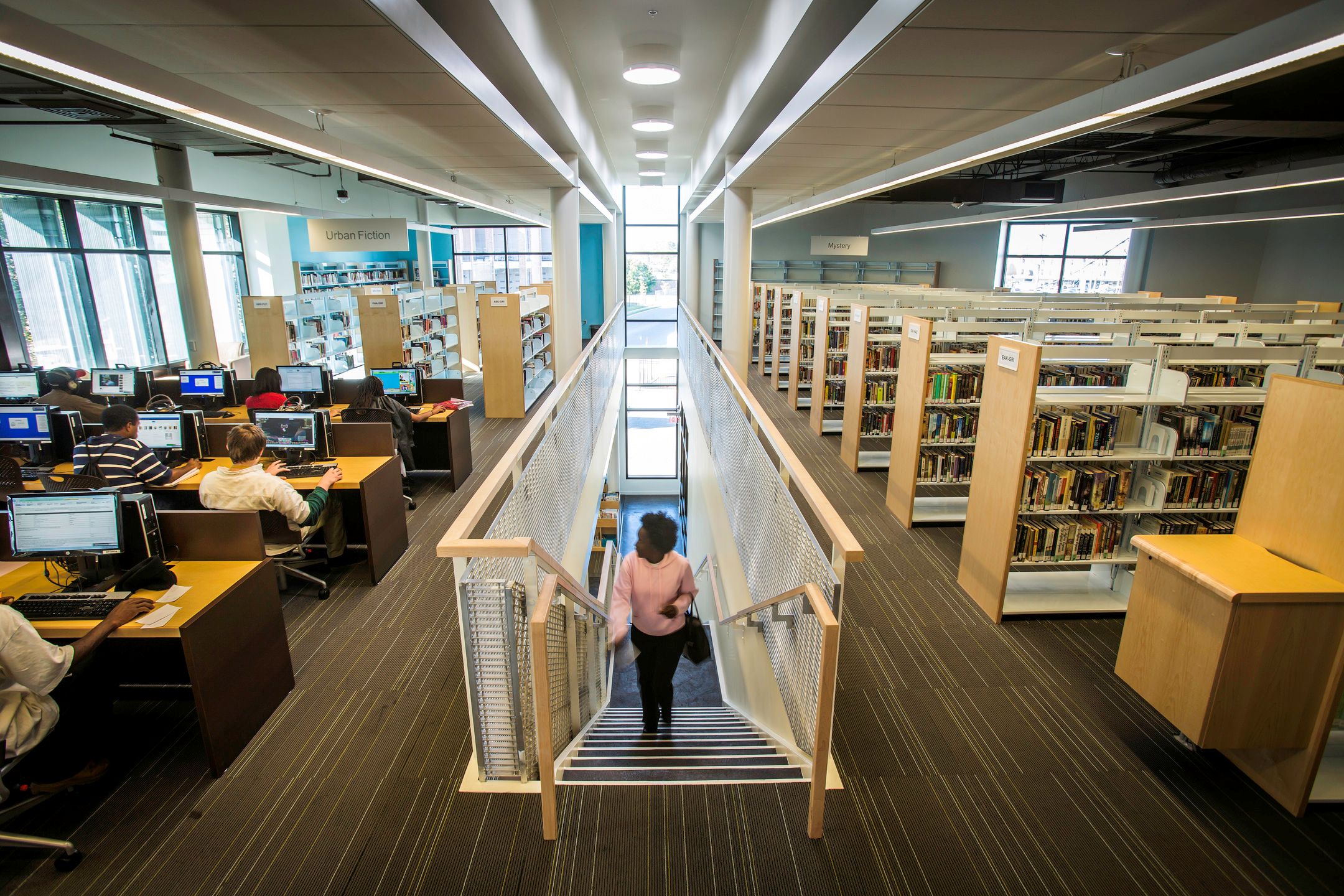 A view of the stairwell, computer area, and library stacks.