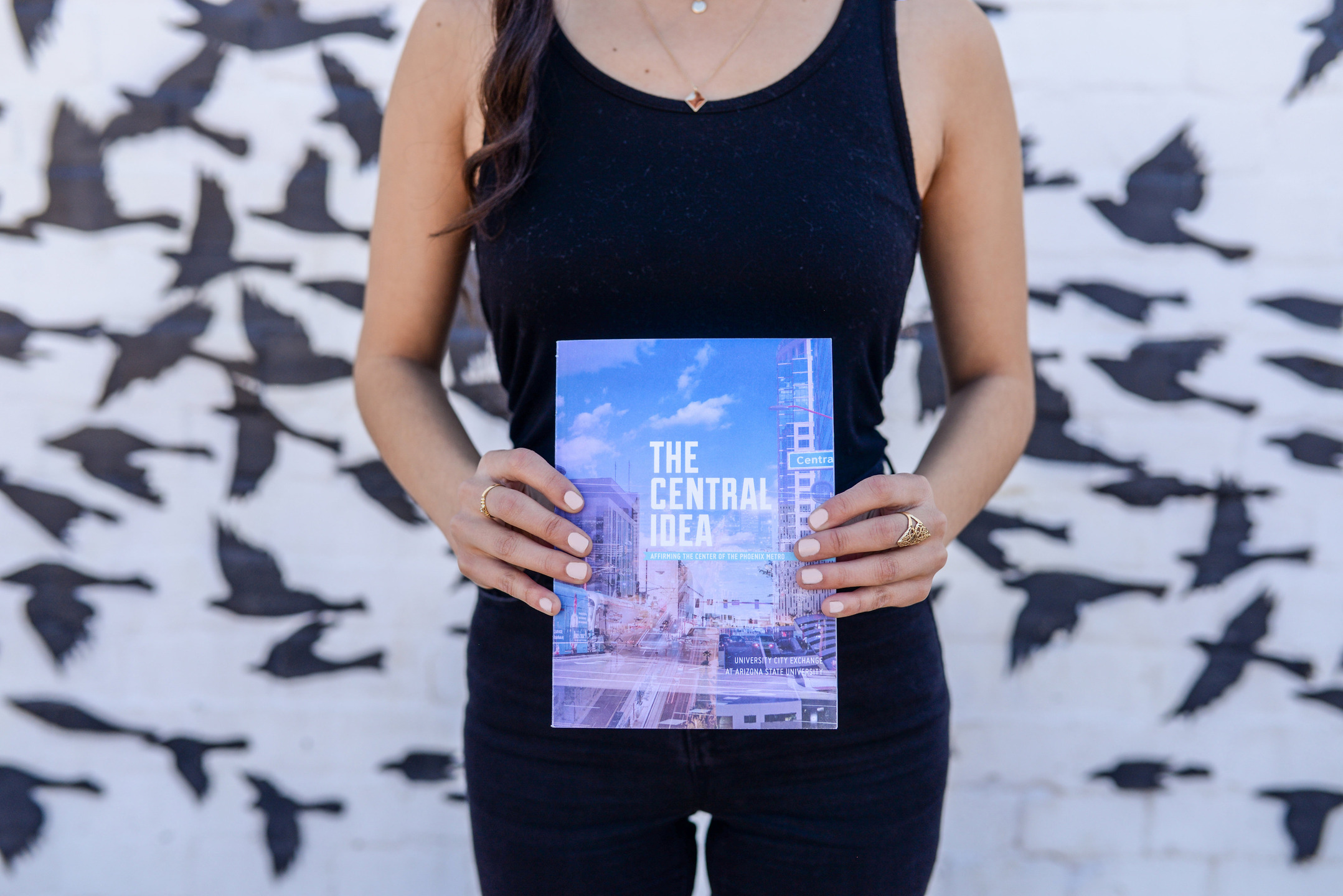 A woman holds a book. The headline reads "The Central Idea". 