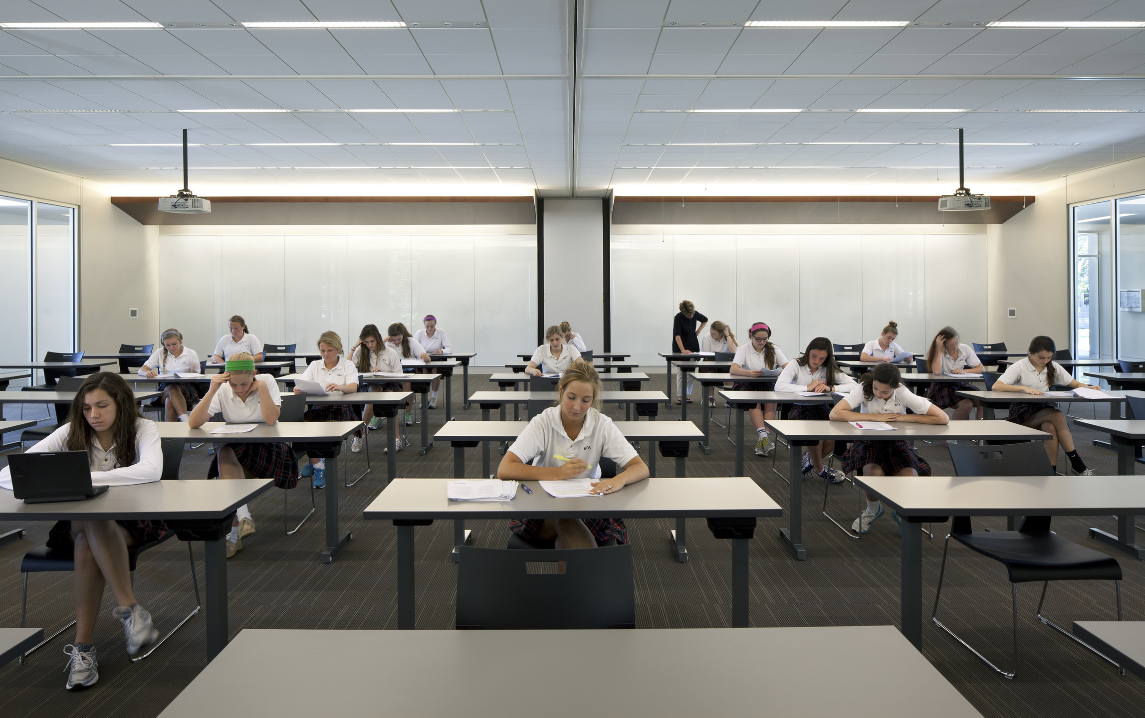 Students in uniform sit at their desks during a lesson.