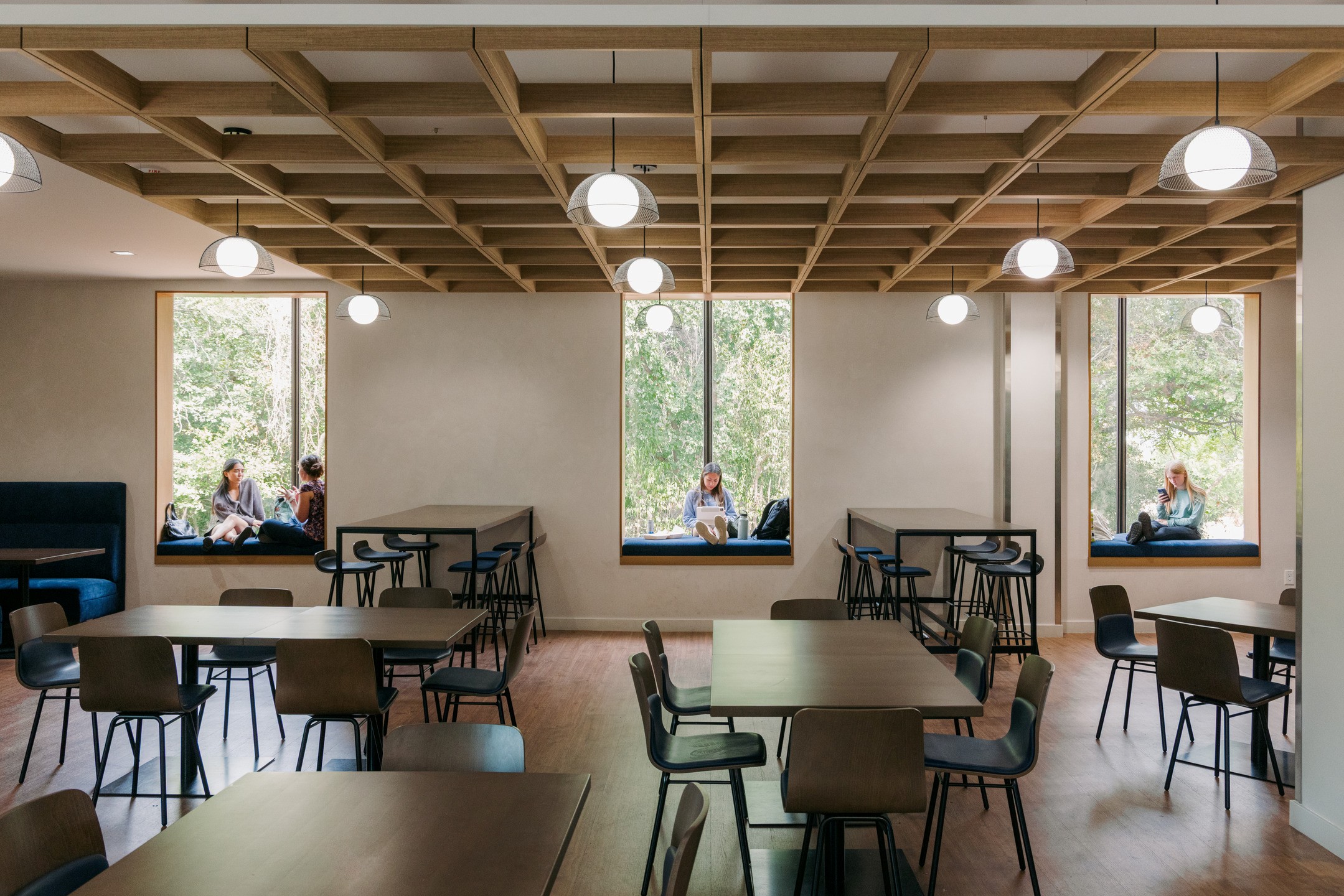 Students use window nooks in a multi-use dining area to study, chat, and text. 